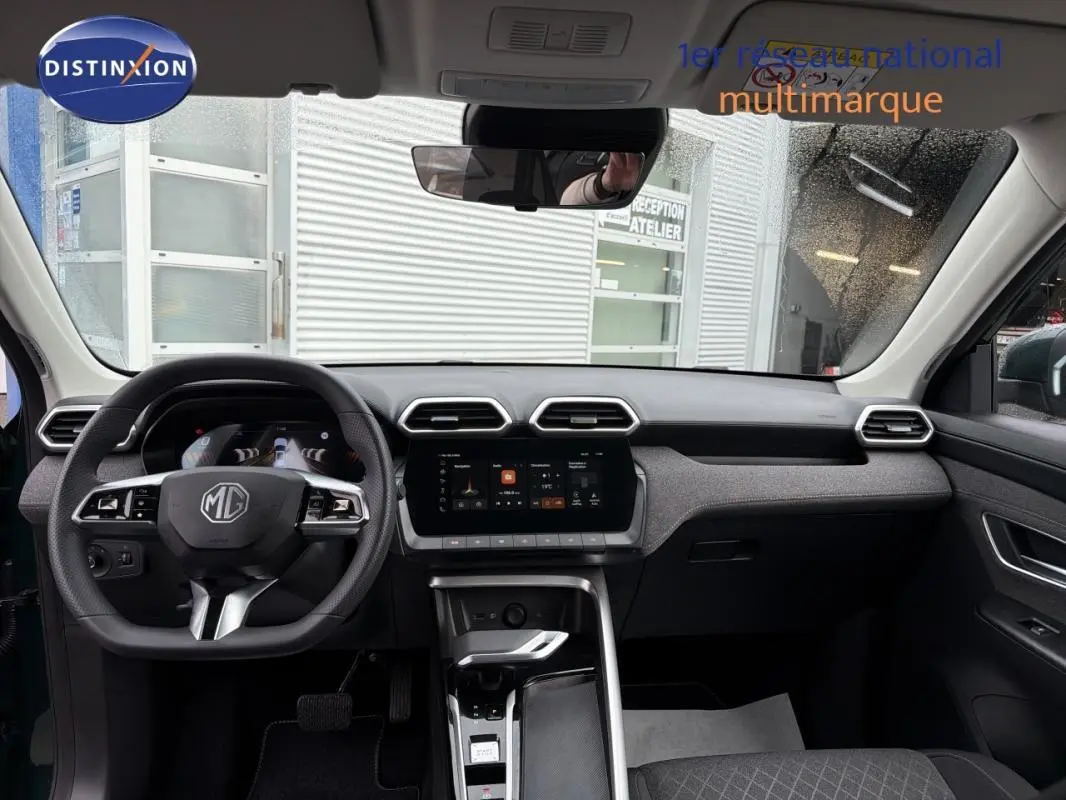 Intérieur du MG MOTOR ZS 2026 vert foncé, vue de face sur le tableau de bord avec écran tactile et volant multifonction.