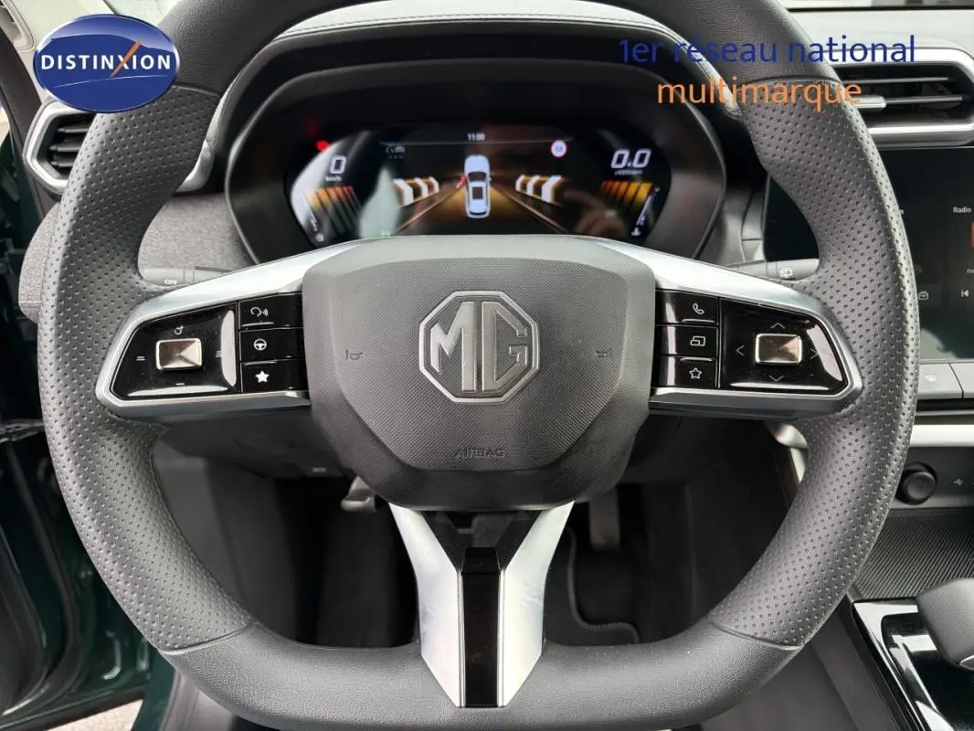 Vue rapprochée du volant perforé noir du MG ZS hybride 2026, avec tableau de bord numérique en arrière-plan.