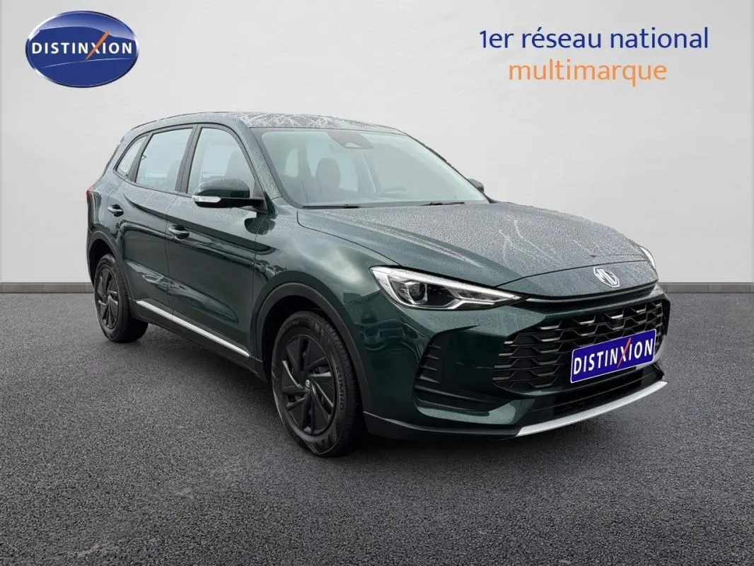MG ZS hybride vert foncé en 3/4 avant droit, avec calandre noire et jantes foncées, sur fond neutre intérieur.