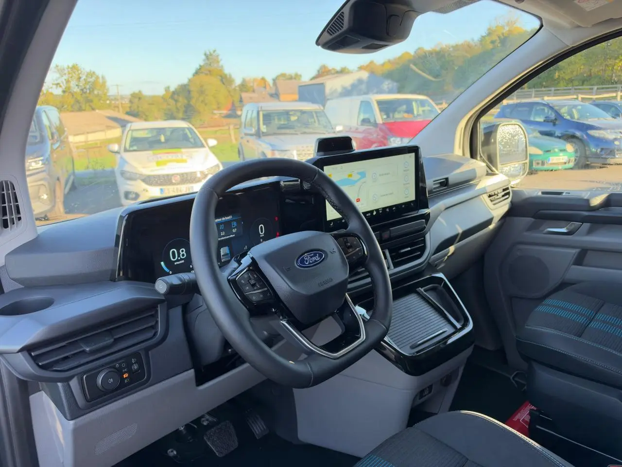 Vue intérieure du poste de conduite du Ford Transit Fourgon 2026, avec tableau de bord numérique et écran tactile central.