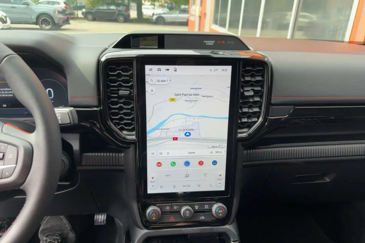 Vue rapprochée du tableau de bord noir du Ford Ranger Wildtrak 2026 avec écran tactile vertical affichant la navigation.