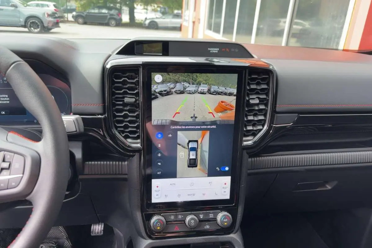Vue intérieure centrée sur l’écran tactile vertical du Ford Ranger gris, avec tableau de bord noir et volant partiel visible.
