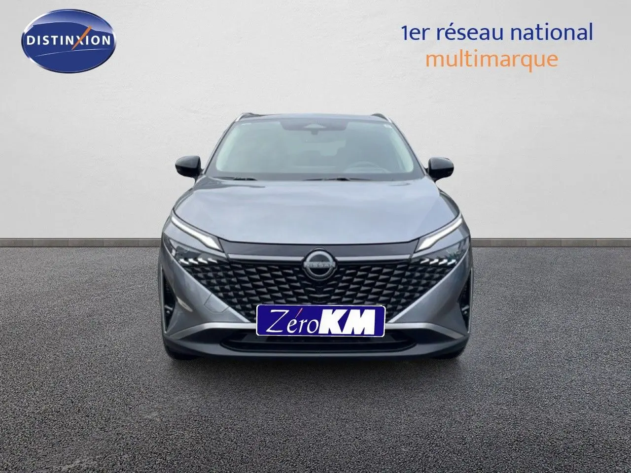 Vue avant d'un Nissan Qashqai 2025 gris squale métal avec calandre noire et phares LED fins.