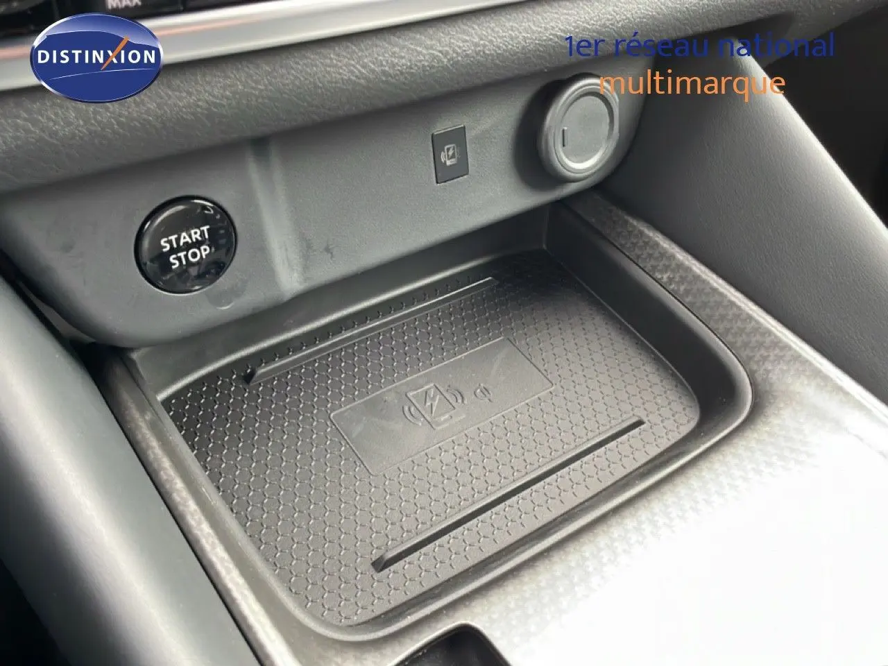 Gros plan sur la console centrale du Nissan Qashqai 2025, zone de recharge sans fil et bouton start/stop visible.