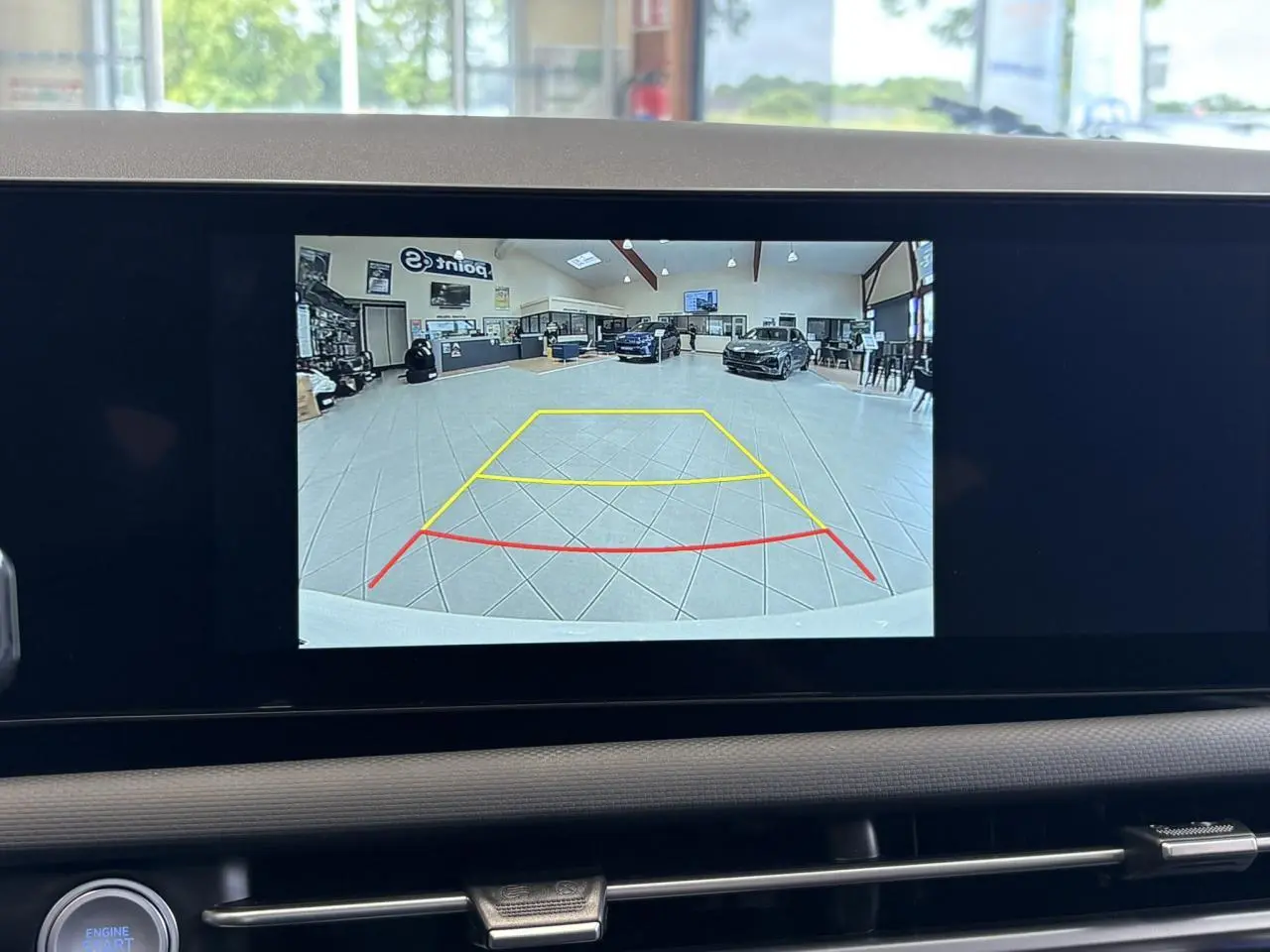 Vue écran caméra de recul intérieur du Hyundai Tucson 2026 Serenity White montrant l'espace derrière en showroom.