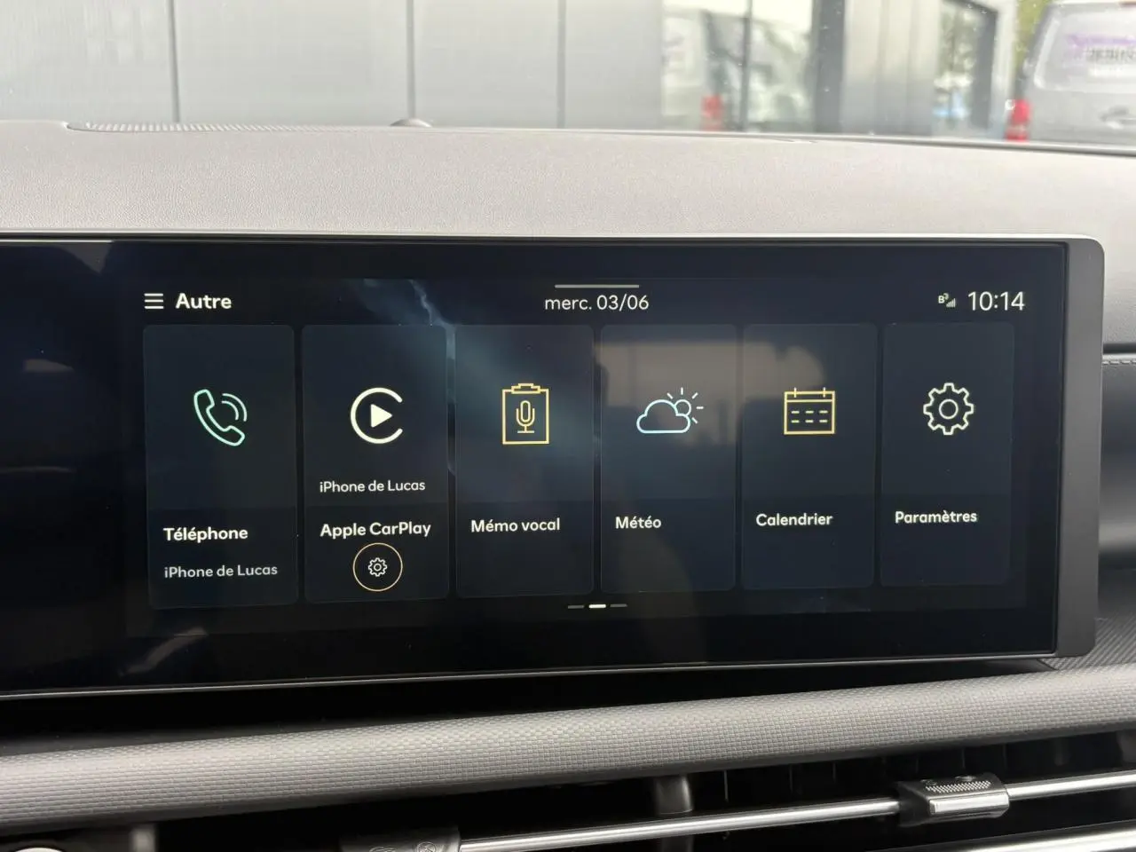 Écran tactile multimédia du Hyundai Tucson 2026 affichant Apple CarPlay et diverses applications, vue de face intérieure.