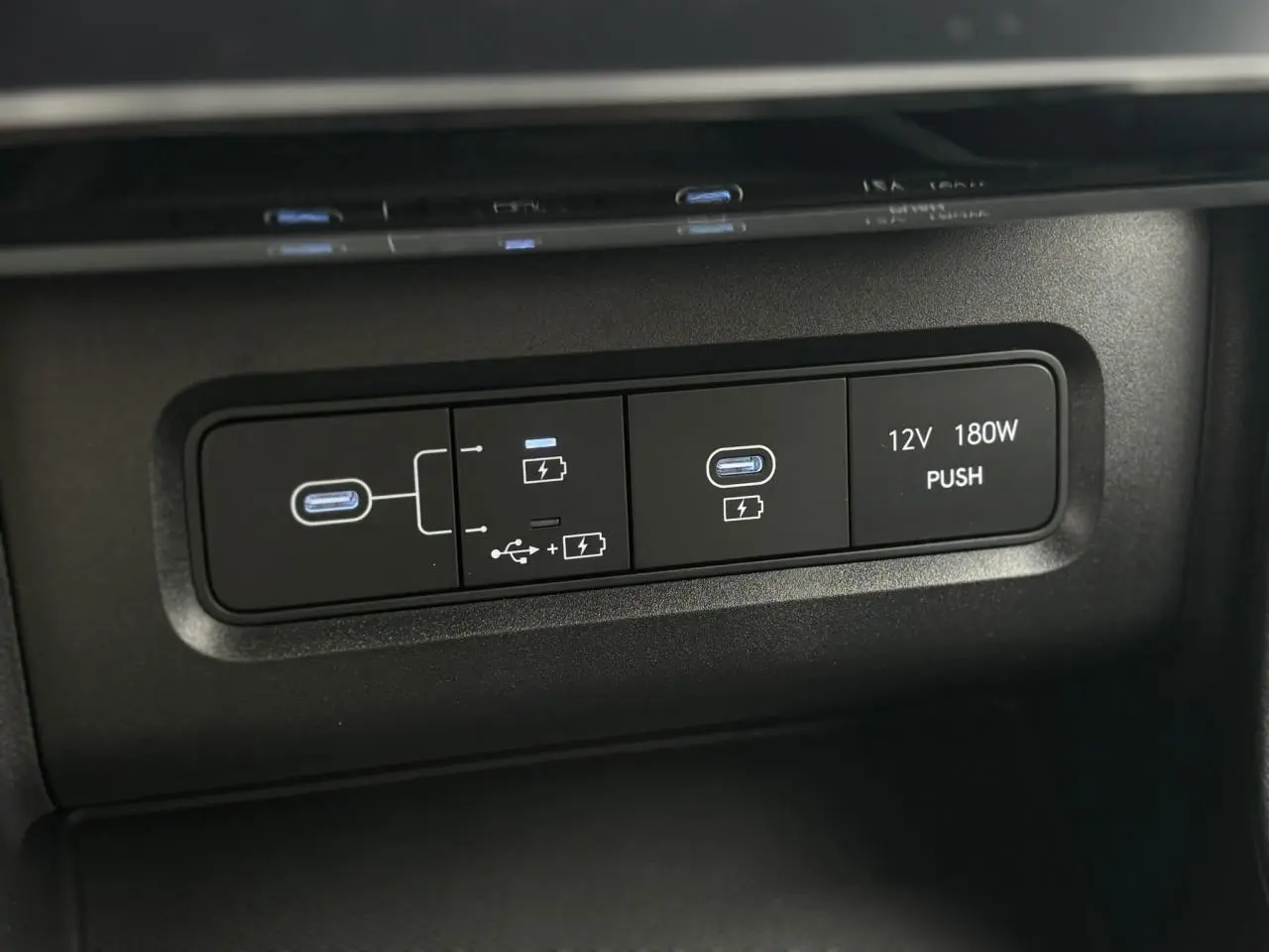 Gros plan sur les ports USB-C et prise 12V du tableau de bord du Hyundai Tucson 2026 en intérieur noir.