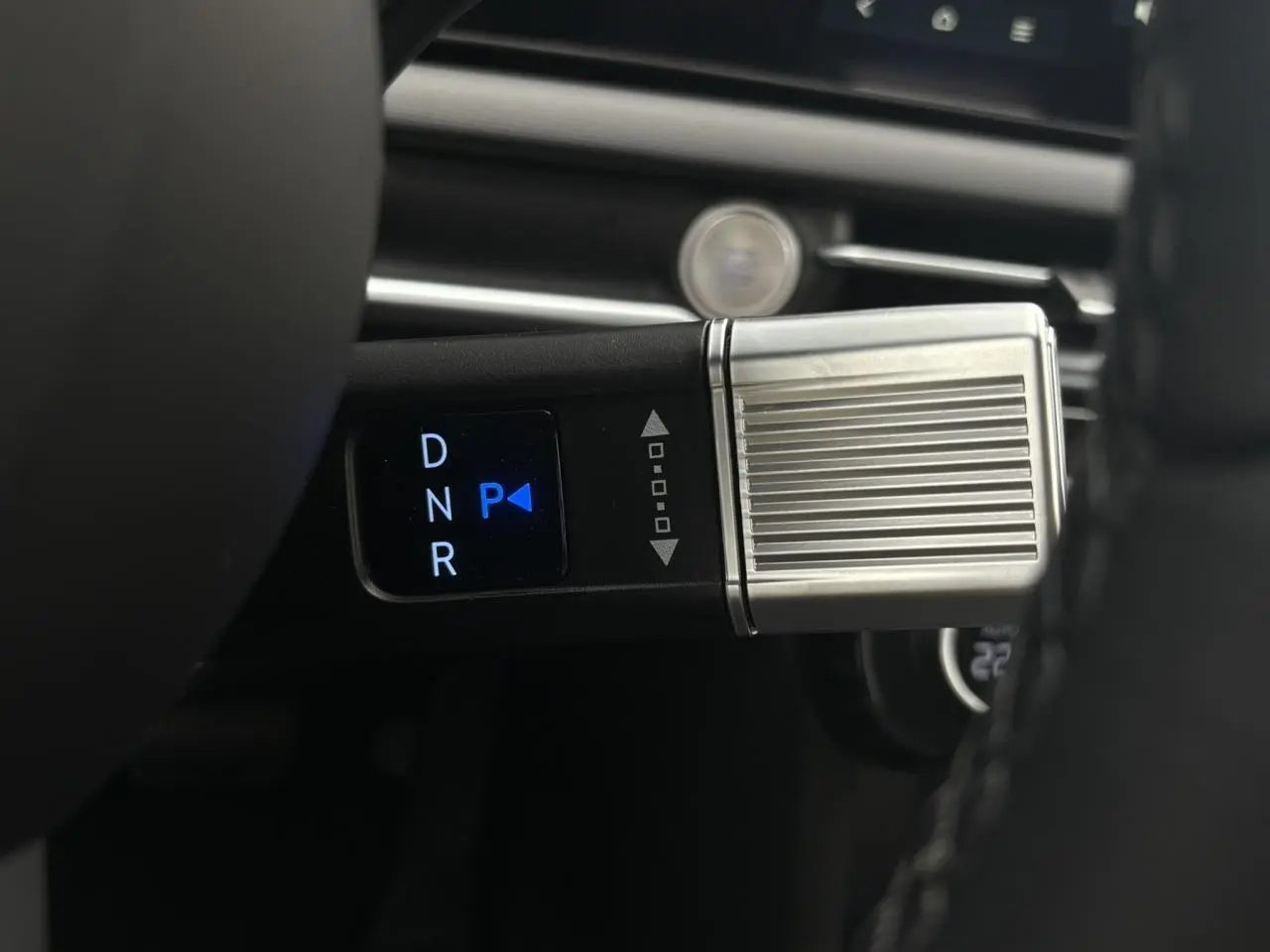 Gros plan sur la commande de boîte automatique avec sélecteur digital et finition métallique dans un Hyundai Tucson blanc.