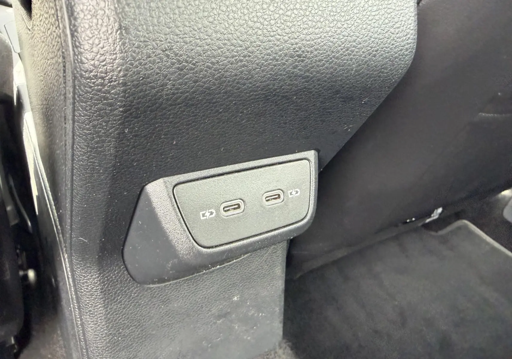Vue rapprochée des ports USB-C de recharge situés à l'arrière de la console centrale d'une Volkswagen Polo bleue.