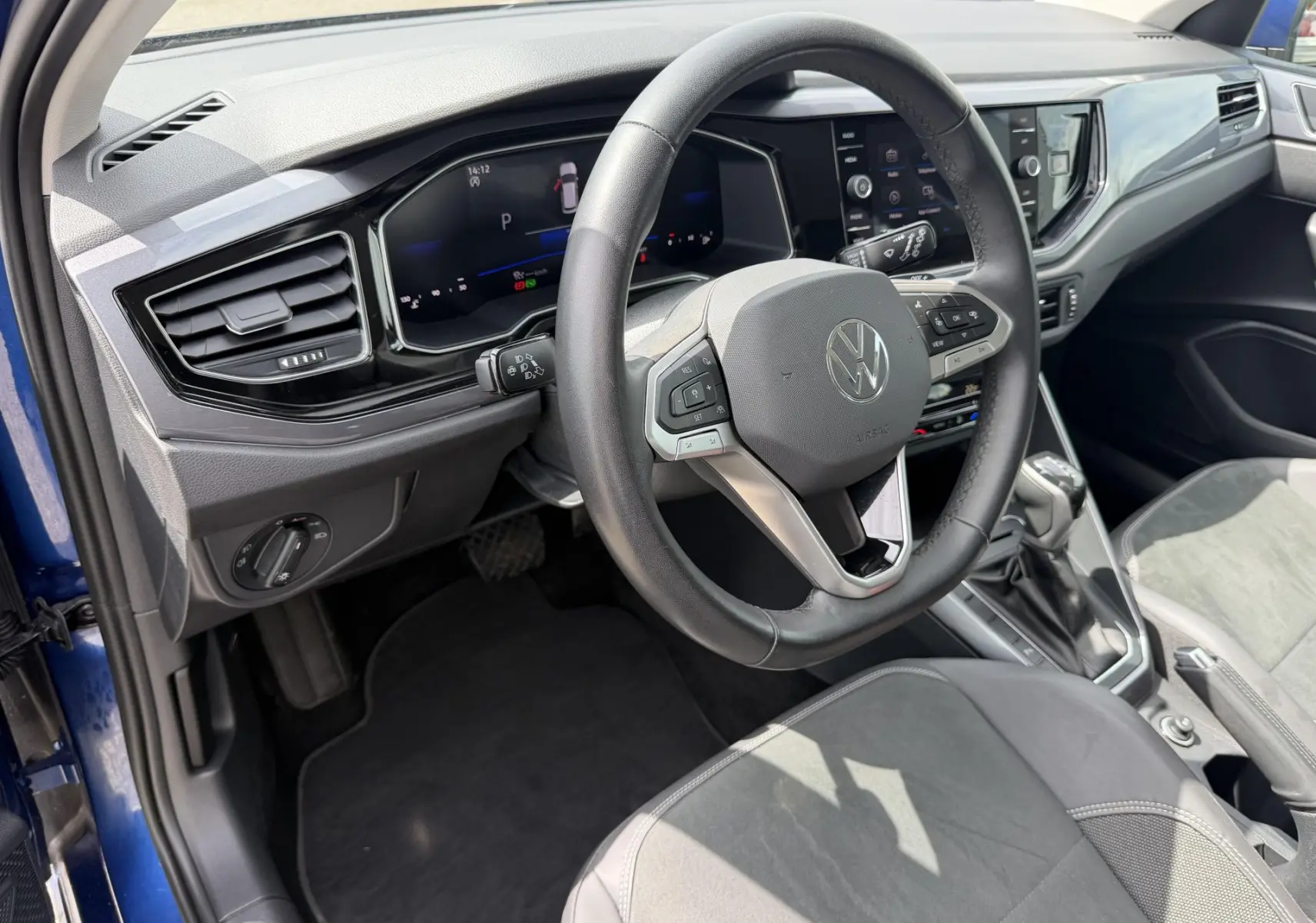Vue intérieure côté conducteur de la Volkswagen Polo bleue 2025, volant cuir multifonctions et tableau de bord digital.