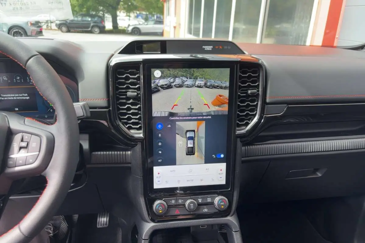 Vue intérieure centrée sur la console centrale tactile verticale du Ford Ranger gris carbone 2026 avec volant multifonctions.