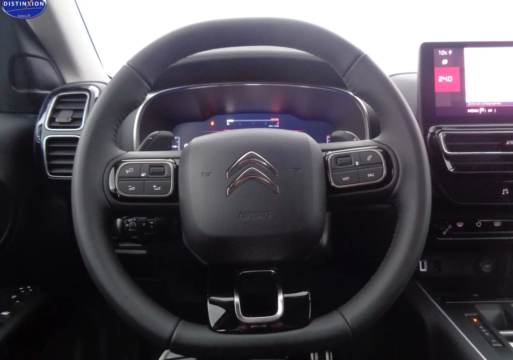 Vue rapprochée du volant noir du Citroën C5 Aircross 2022 avec commandes intégrées et tableau de bord digital.