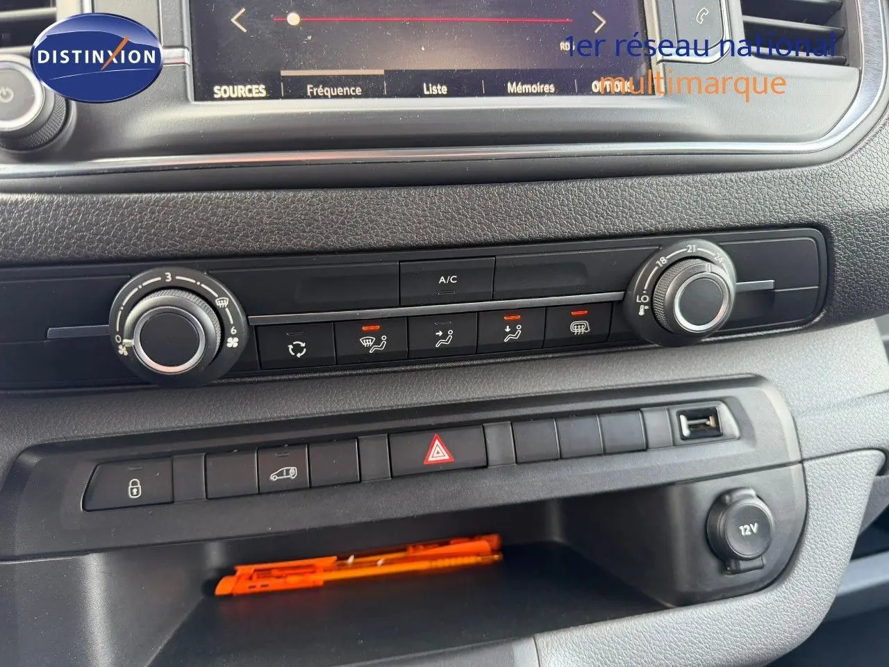 Vue rapprochée du tableau de bord de l'Opel Vivaro Fourgon gris, montrant les commandes de climatisation et les boutons de sécurité.