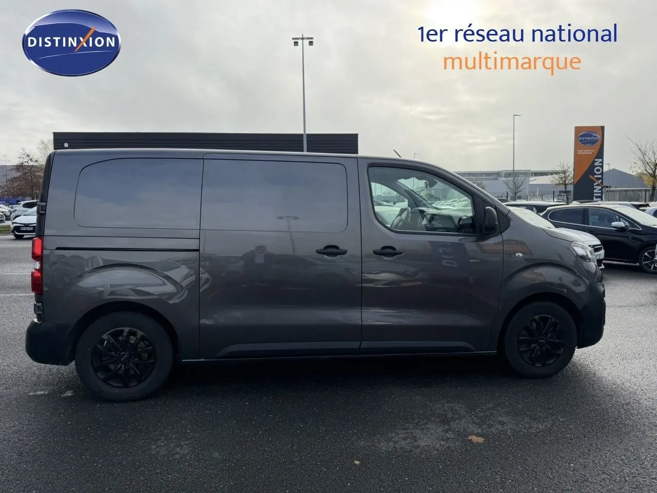 Profil droit d'un Opel Vivaro Fourgon gris Pierre de Lune métallisé avec jantes noires et vitres teintées.