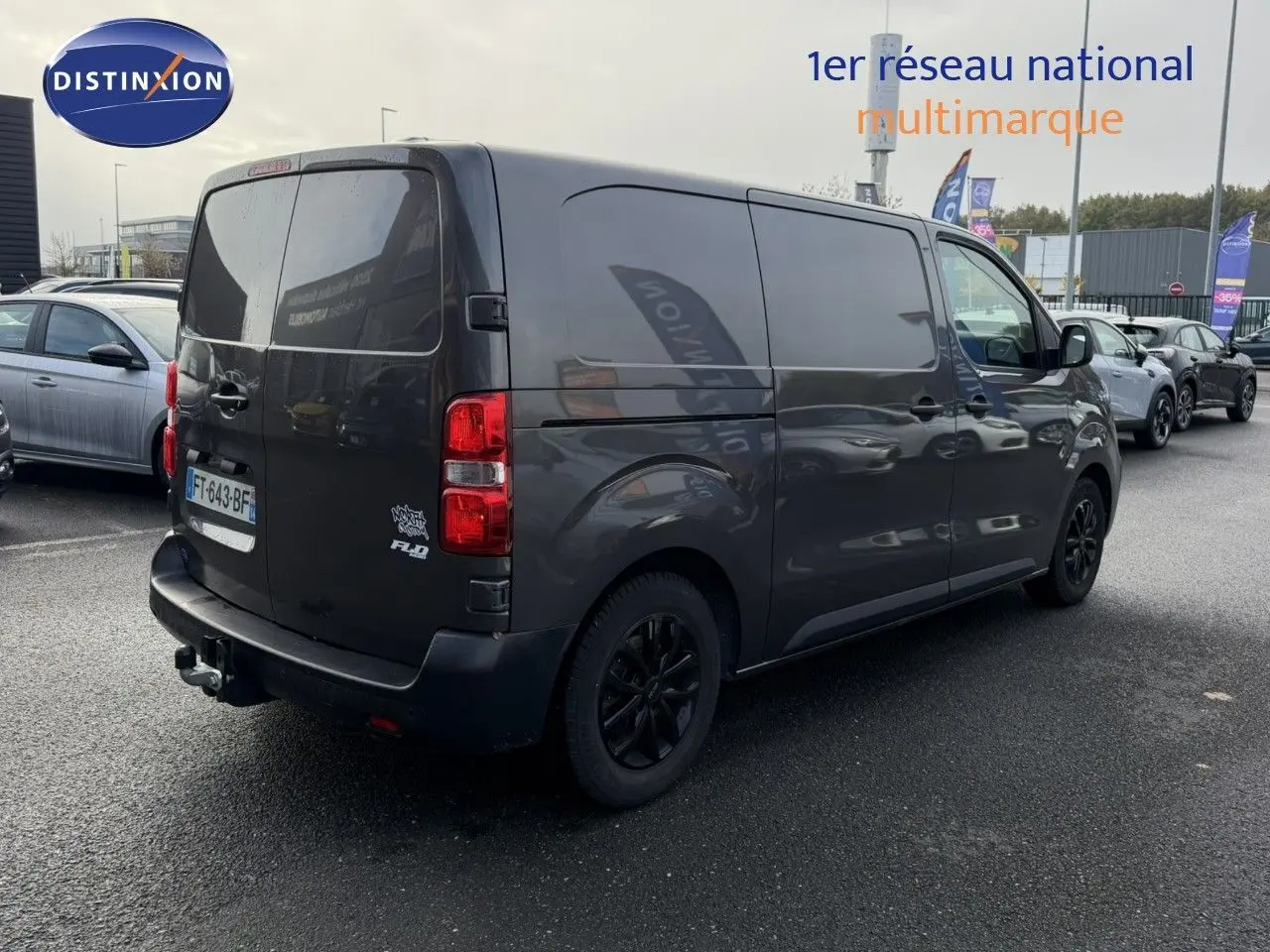 Vue 3/4 arrière droit d'un Opel Vivaro Fourgon gris Pierre de Lune métallisé avec attelage et jantes noires.