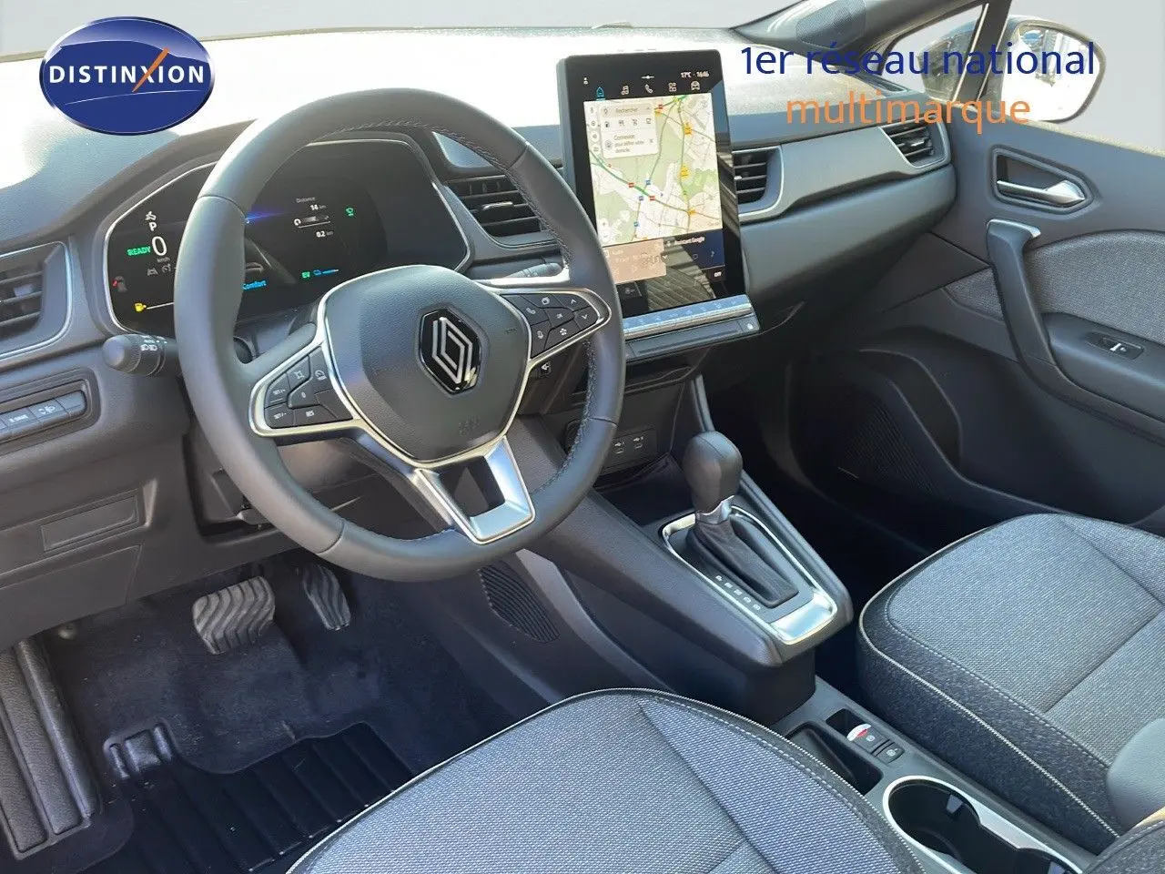 Intérieur avant du Renault Captur E-Tech hybride 2025, tableau de bord moderne avec écran tactile vertical et volant multifonction.