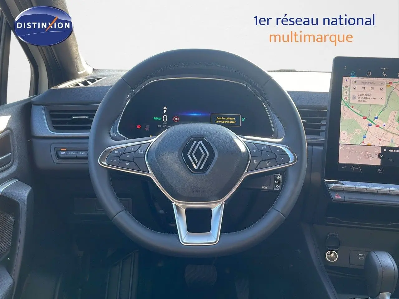 Vue centrée sur le volant du Renault Captur E-Tech hybride 2025, avec tableau de bord numérique et écran tactile visible.