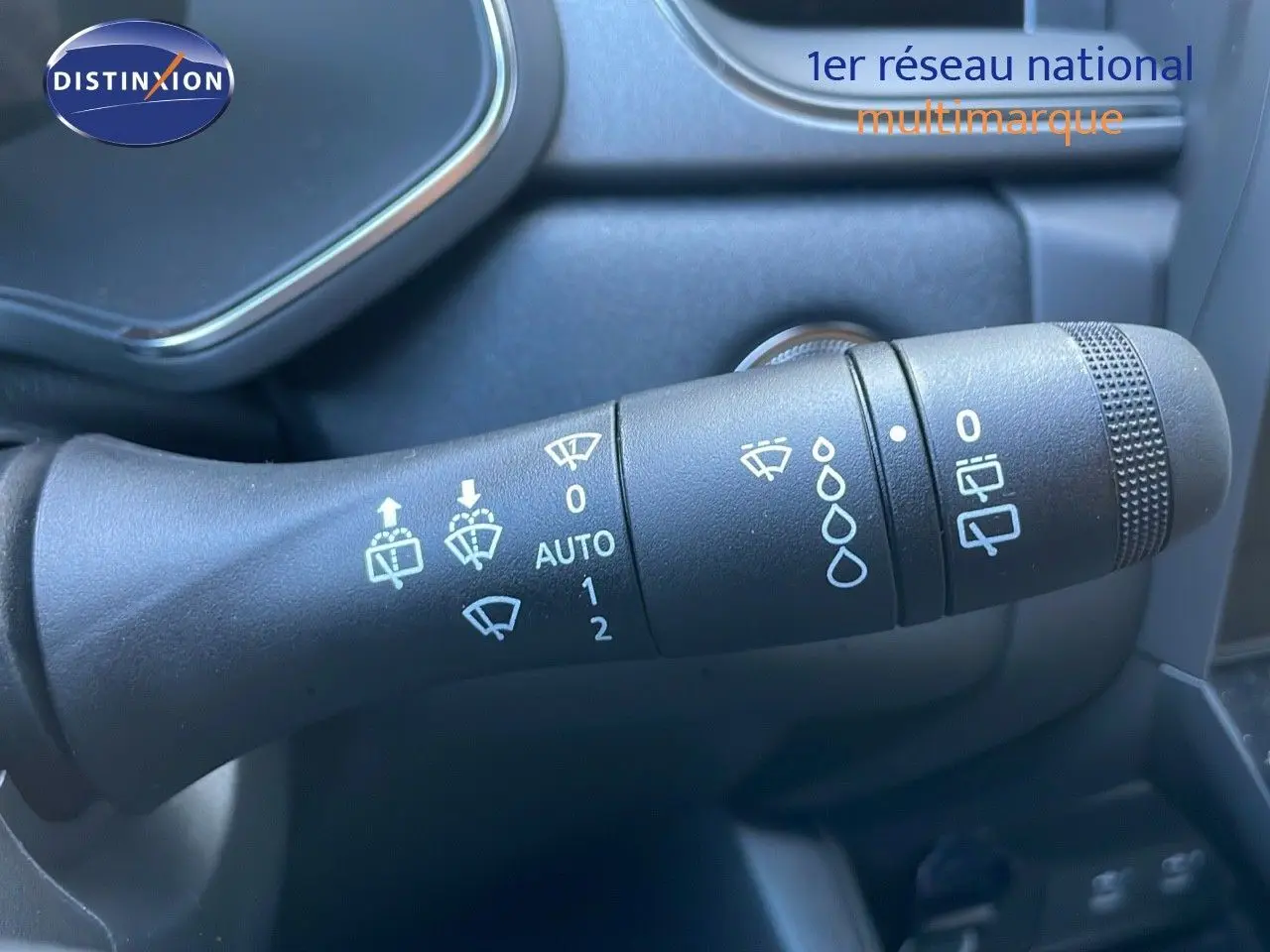 Gros plan sur la commande d’essuie-glace du Renault Captur blanc nacré 2025, avec pictogrammes clairs et molette texturée.