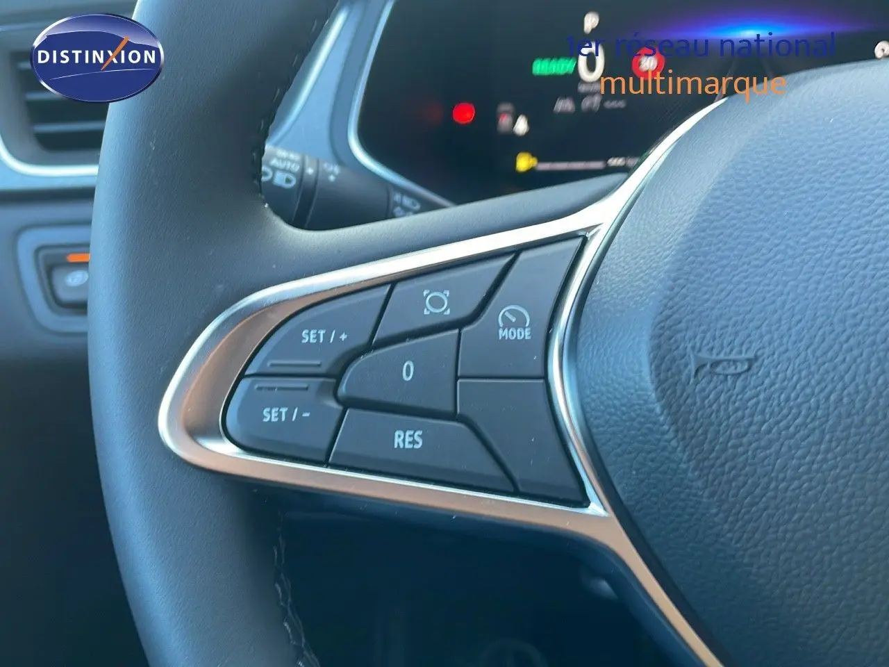Gros plan sur les commandes au volant du Renault Captur E-Tech blanc nacré avec toit noir, version hybride 2025.