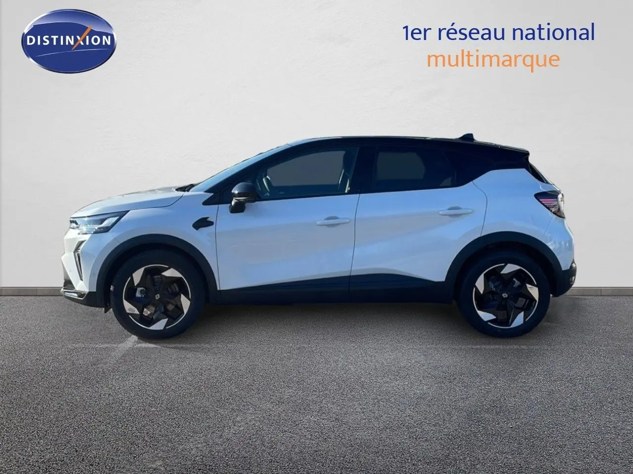 Profil latéral gauche du Renault Captur E-Tech blanc nacré avec toit noir, soulignant ses jantes noires et design moderne.