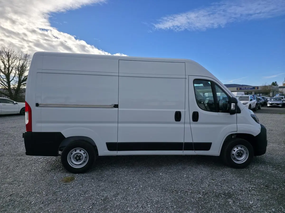 Vue latérale droite d'un FIAT Ducato Fourgon blanc avec porte coulissante tôlée et jantes acier 15 pouces.