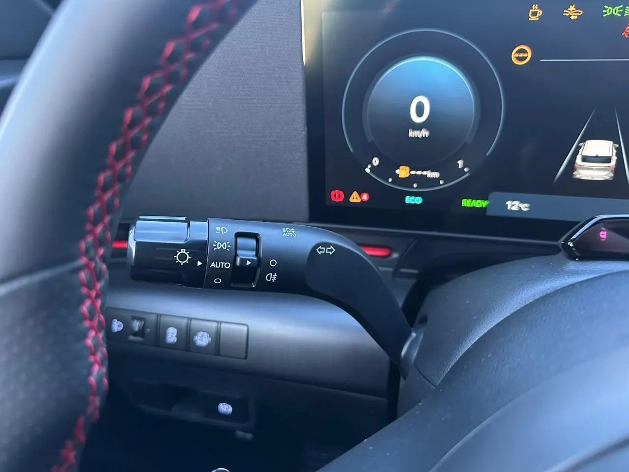 Gros plan sur le volant noir avec surpiqûres rouges et le combiné d'instruments numérique du Hyundai Kona 2026.