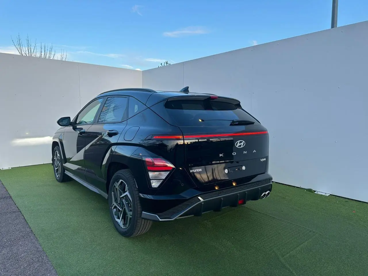 Vue 3/4 arrière droite d’un Hyundai Kona II noir Abyss Metal avec feux arrière LED et jantes alliage 18 pouces.