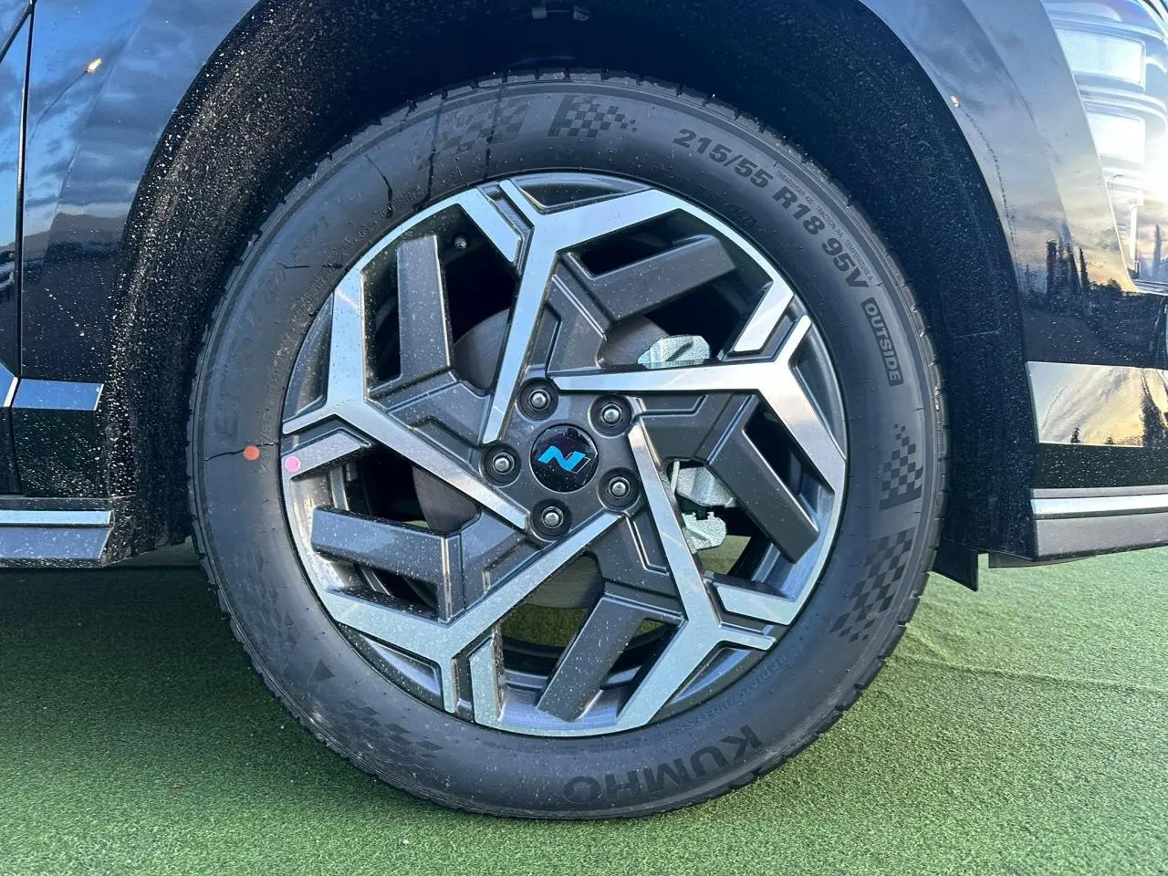 Gros plan sur la jante alliage 18'' noire et grise du Hyundai Kona II noir Abyss Metal, côté avant droit.