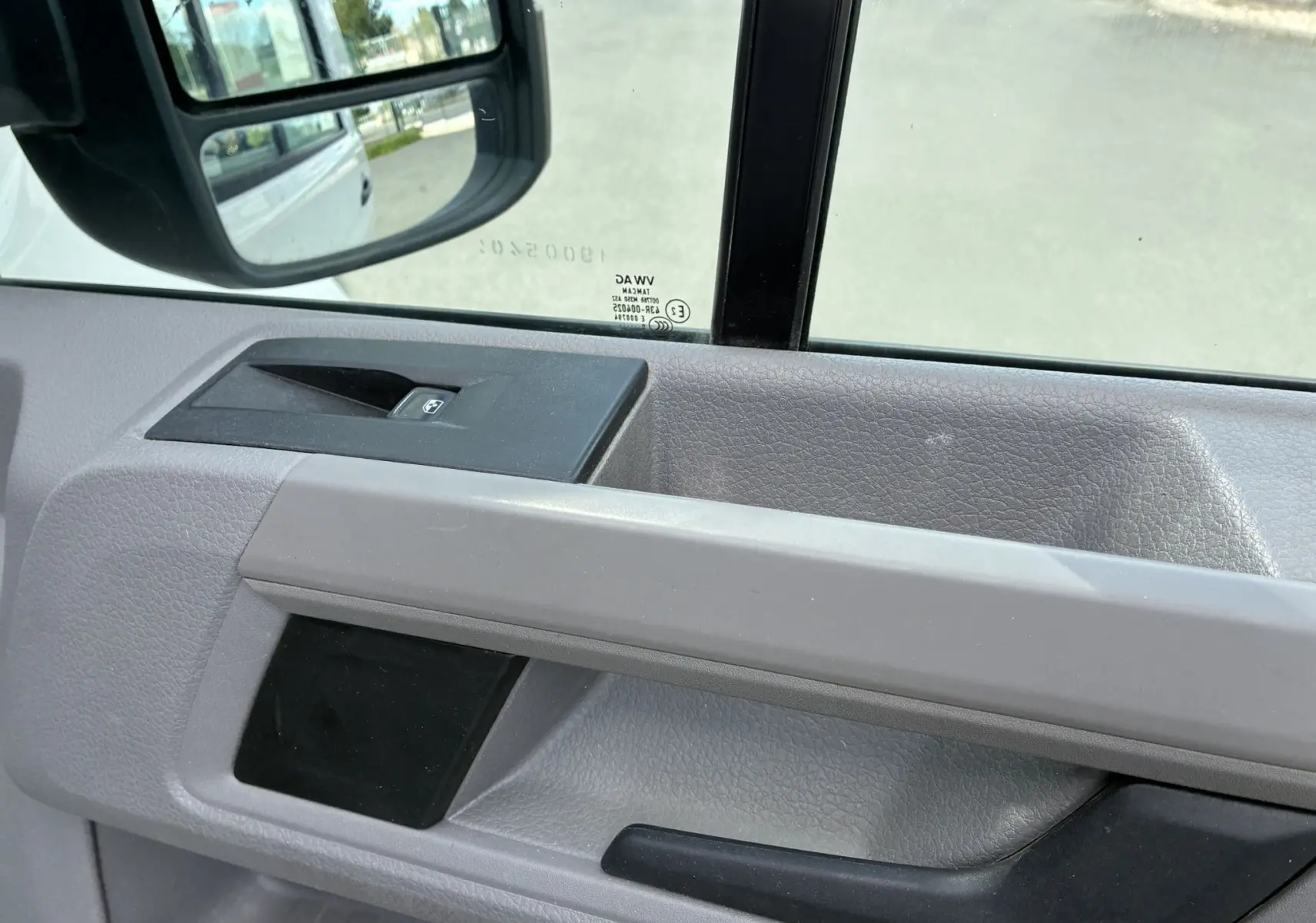 Détail de la porte intérieure côté conducteur du Volkswagen Crafter blanc, avec commande de vitre électrique visible.