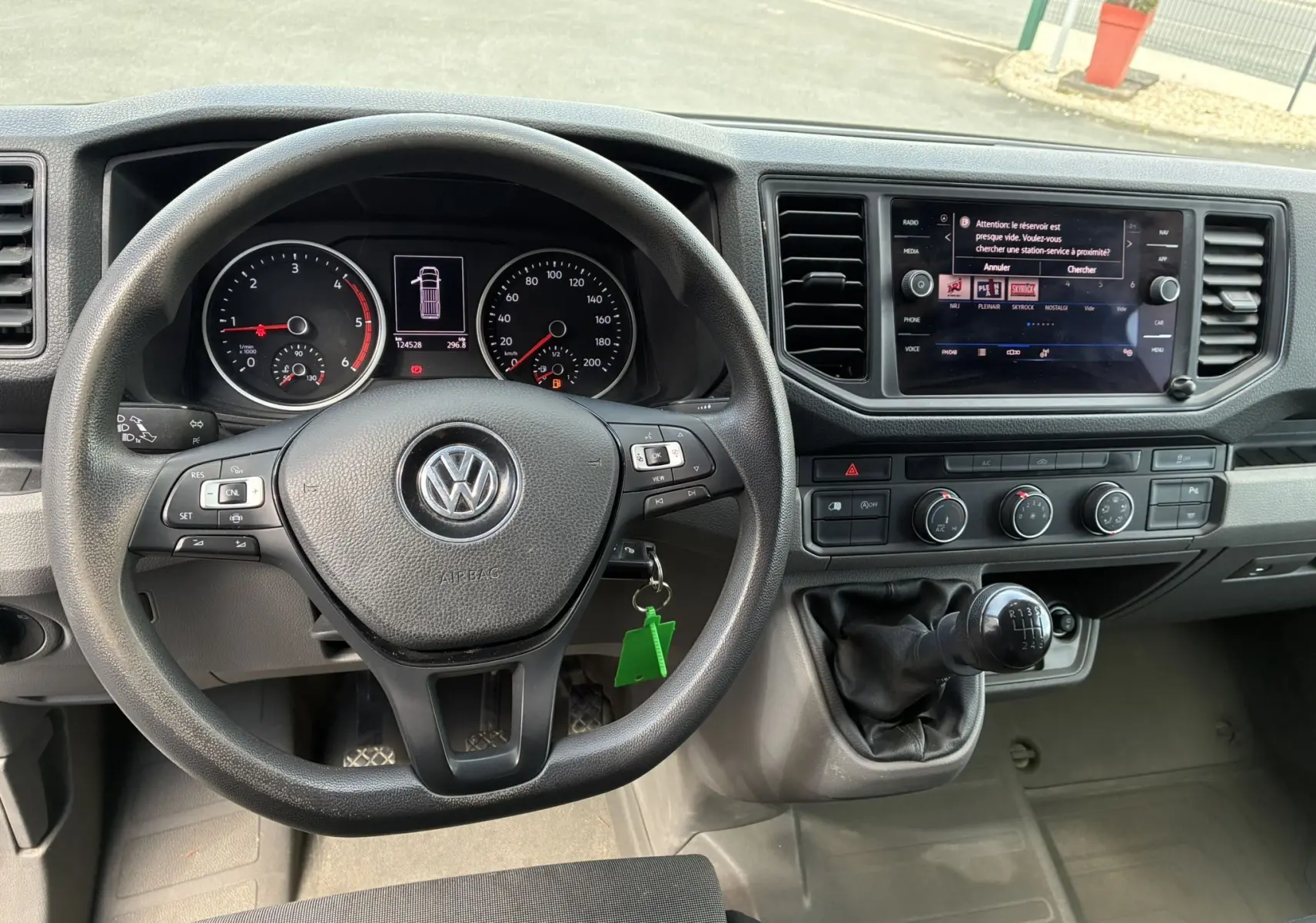 Vue intérieure du tableau de bord et volant noir du Volkswagen Crafter Fourgon avec levier de vitesses manuel et écran tactile.