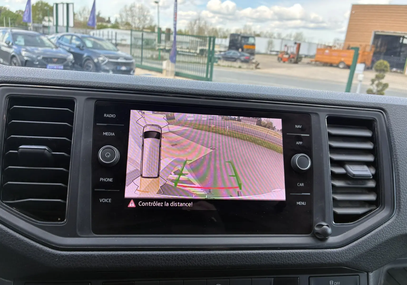 Écran tactile du tableau de bord du Volkswagen Crafter blanc montrant la caméra de recul avec alertes de distance.