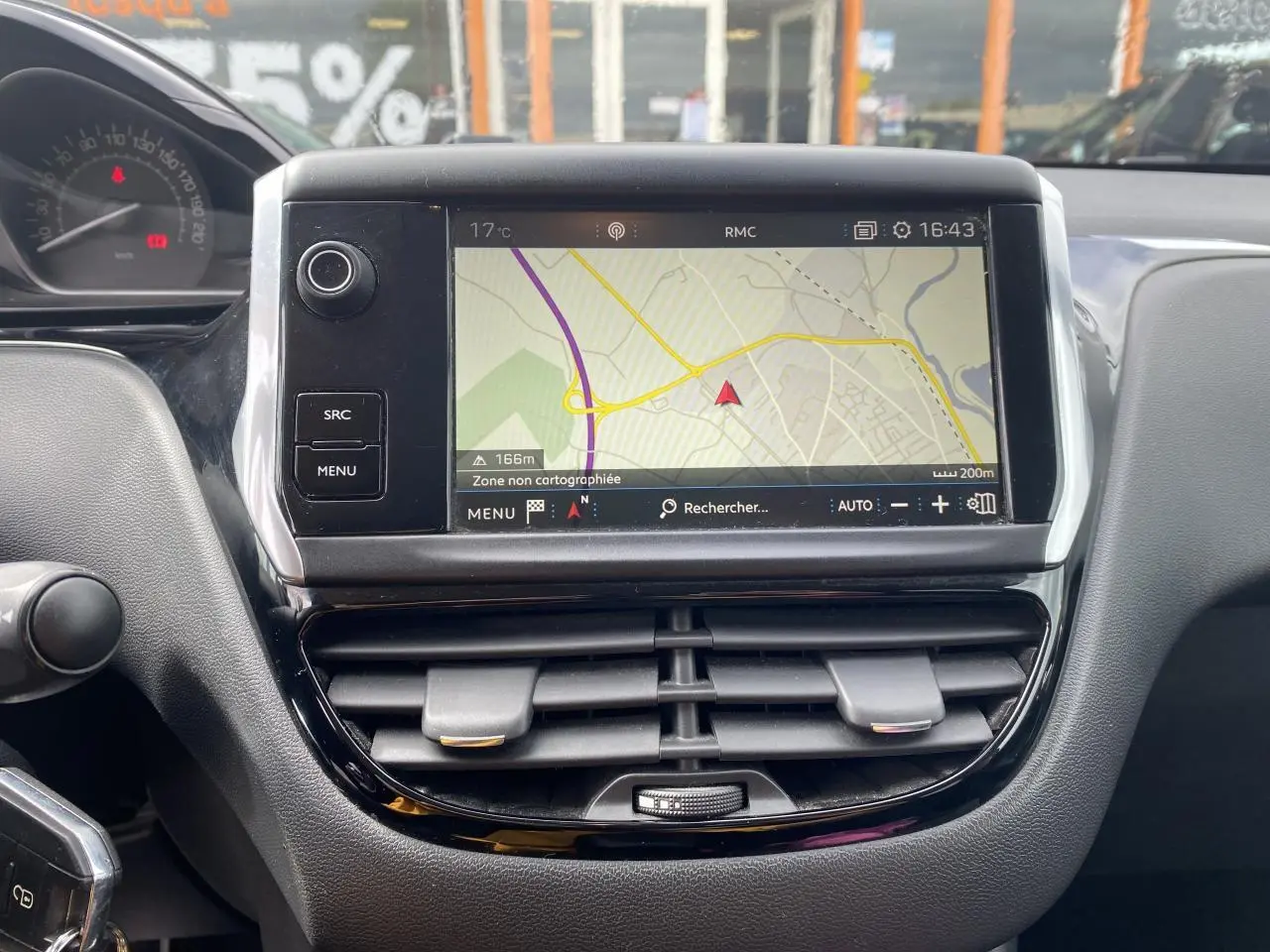 Vue rapprochée de l’écran tactile central et des aérateurs noirs du tableau de bord de la Peugeot 208 gris 2018.