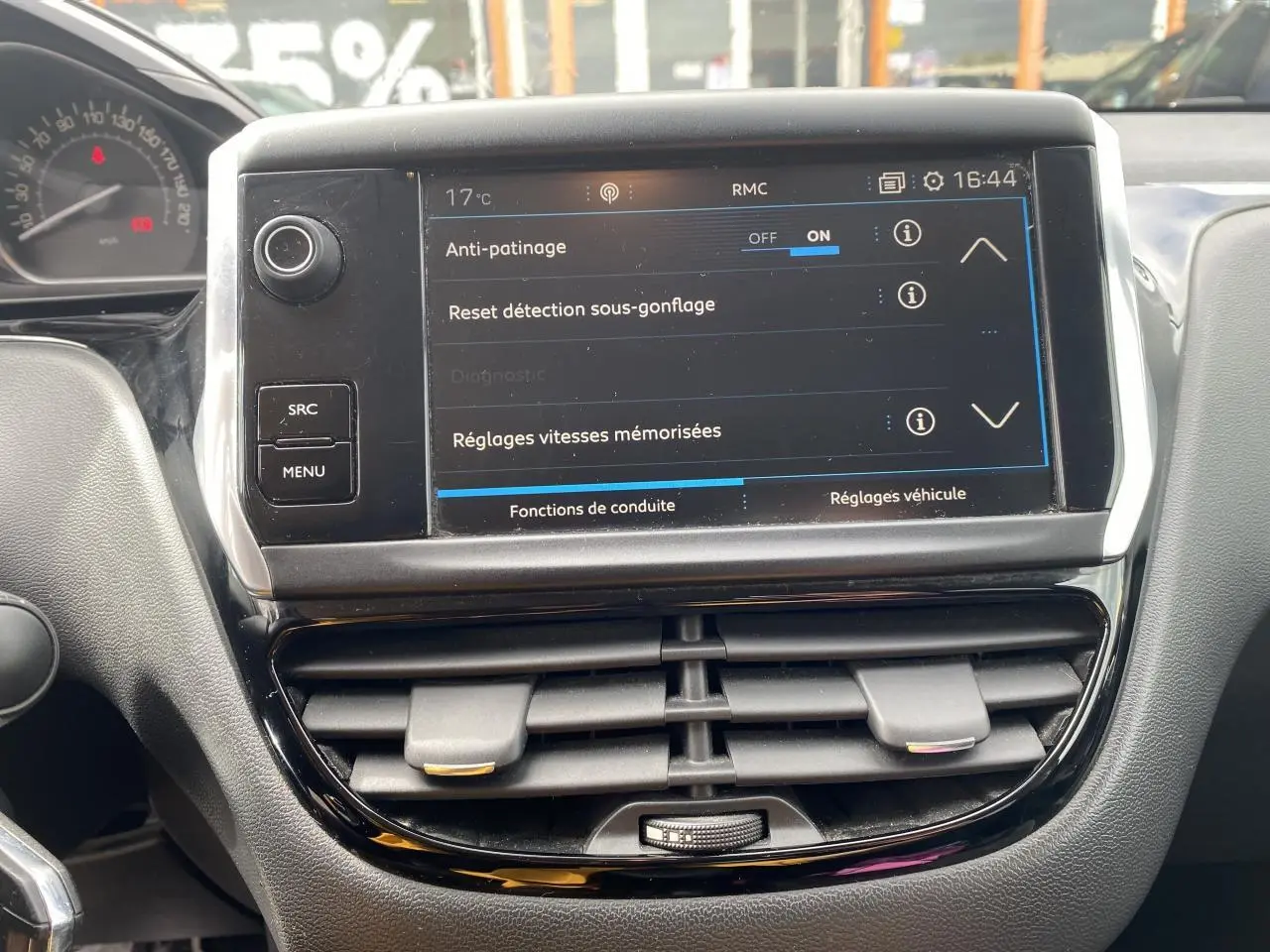 Vue rapprochée de la console centrale de la Peugeot 208 grise, avec écran tactile affichant les réglages de conduite.