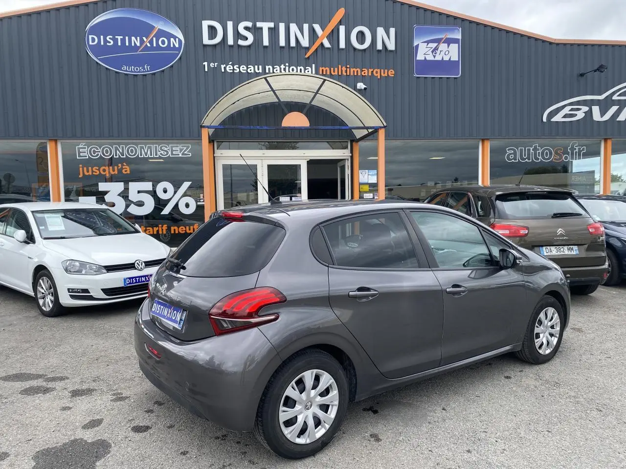 Vue 3/4 arrière droite d'une Peugeot 208 gris métallisé 2018, avec feux arrière LED et jantes acier à enjoliveurs.