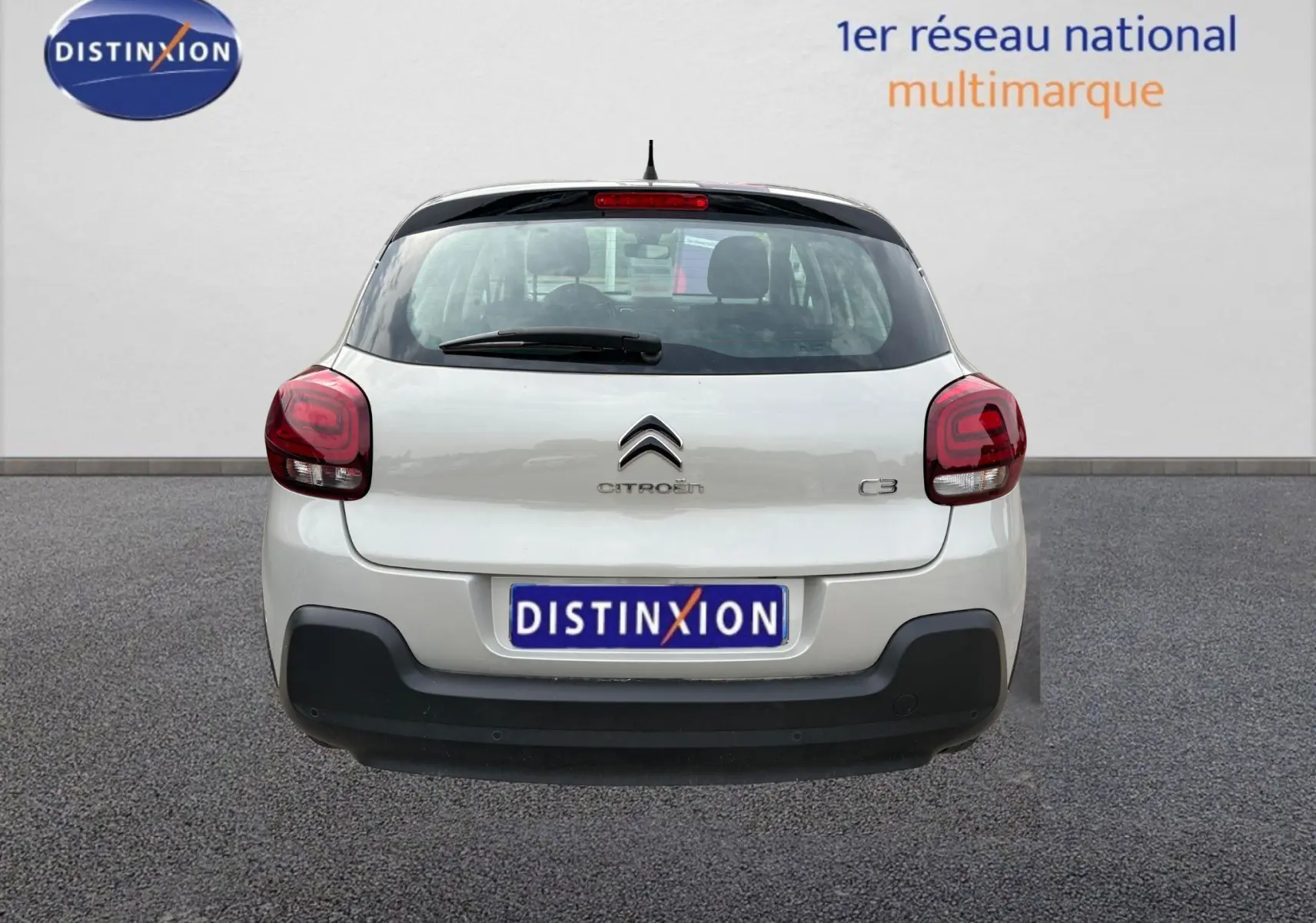 Vue arrière d'une Citroën C3 beige 2019 avec feux rouges et pare-chocs noir, immatriculée Distinxion.