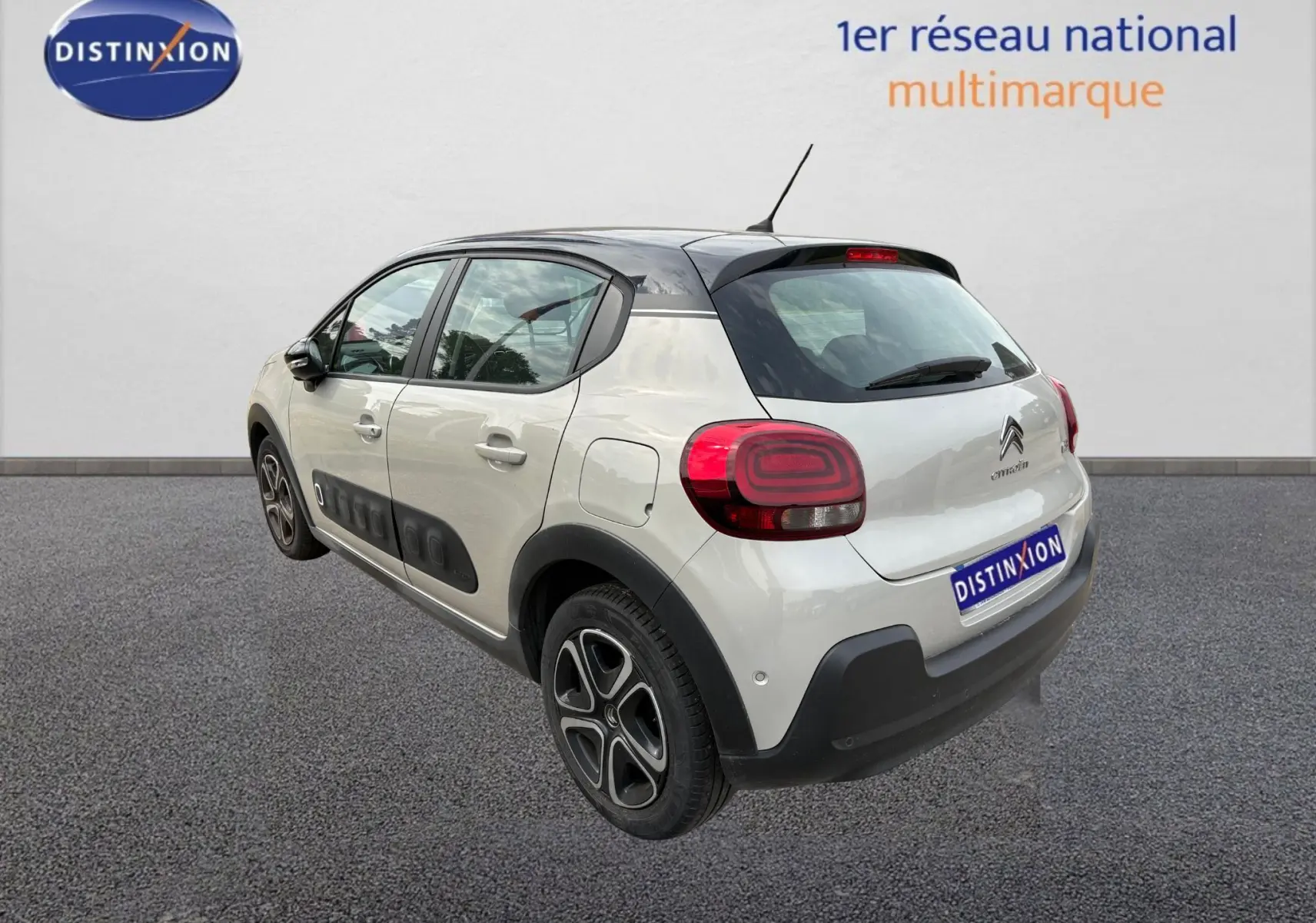 Vue 3/4 arrière droite d'une Citroën C3 beige 2019 avec toit noir et protections latérales noires.