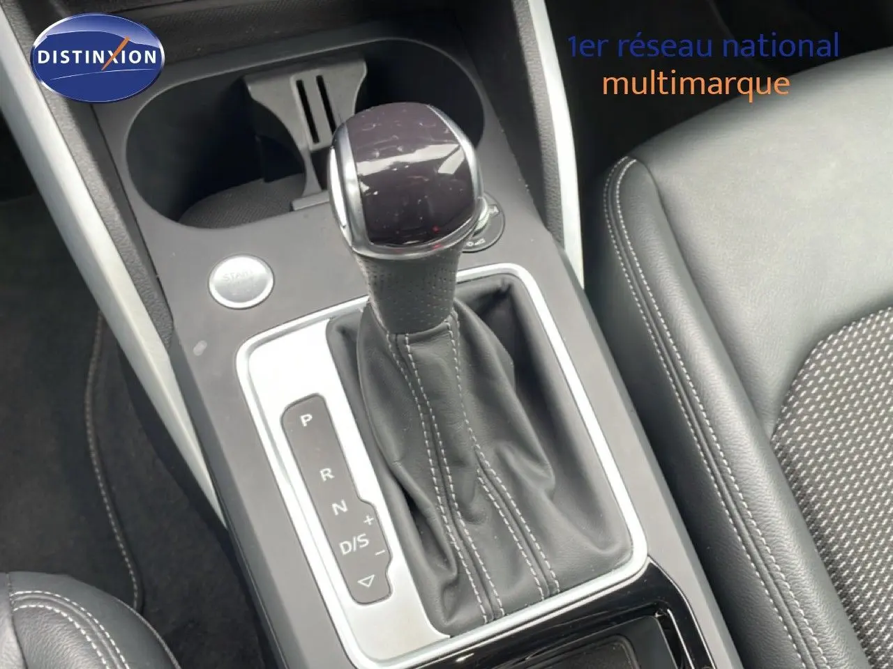 Gros plan sur la commande de boîte automatique noire avec surpiqûres blanches dans l'Audi Q2 35 2.0 TDI S-Line.