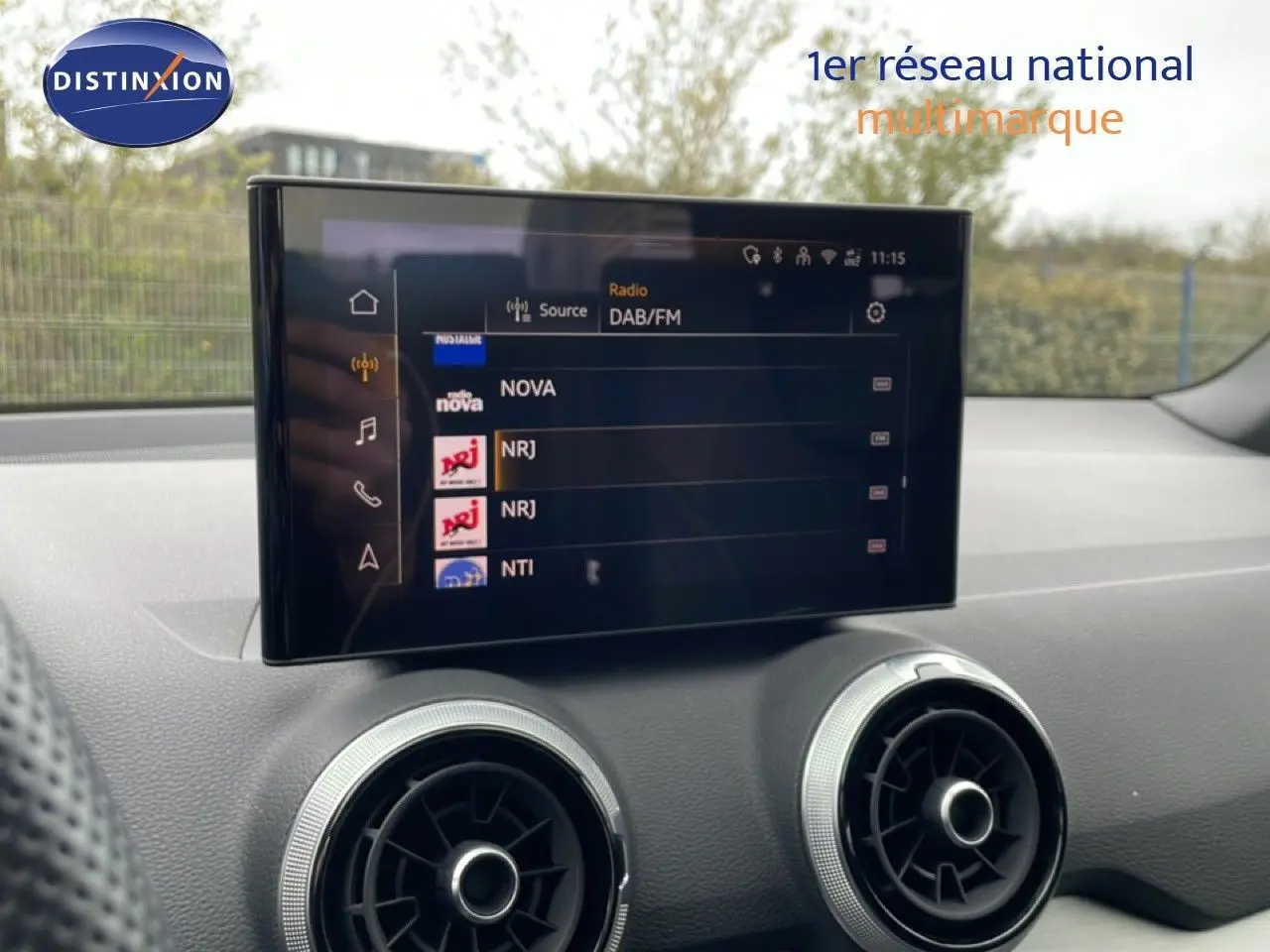 Vue rapprochée de l’écran multimédia et des aérateurs ronds du tableau de bord d’un Audi Q2 noir mito metal.