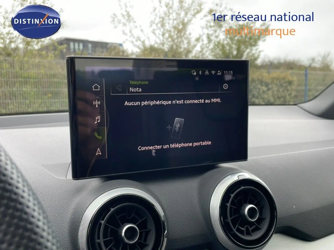 Écran tactile central et aérateurs ronds du tableau de bord intérieur d’un Audi Q2 noir mito metal.