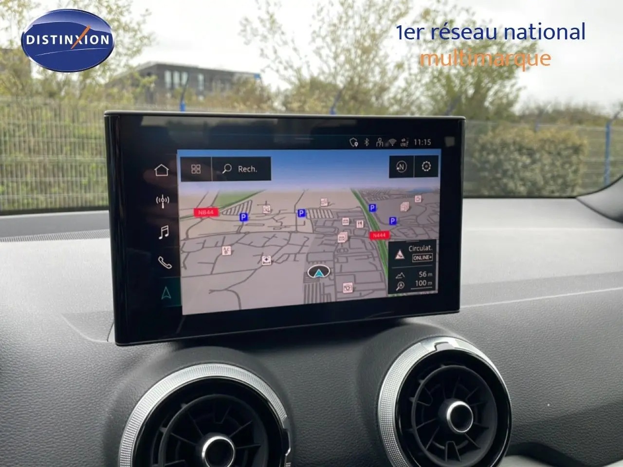Vue intérieure du tableau de bord de l'Audi Q2 2025 avec écran tactile affichant la navigation et aérateurs ronds argentés.