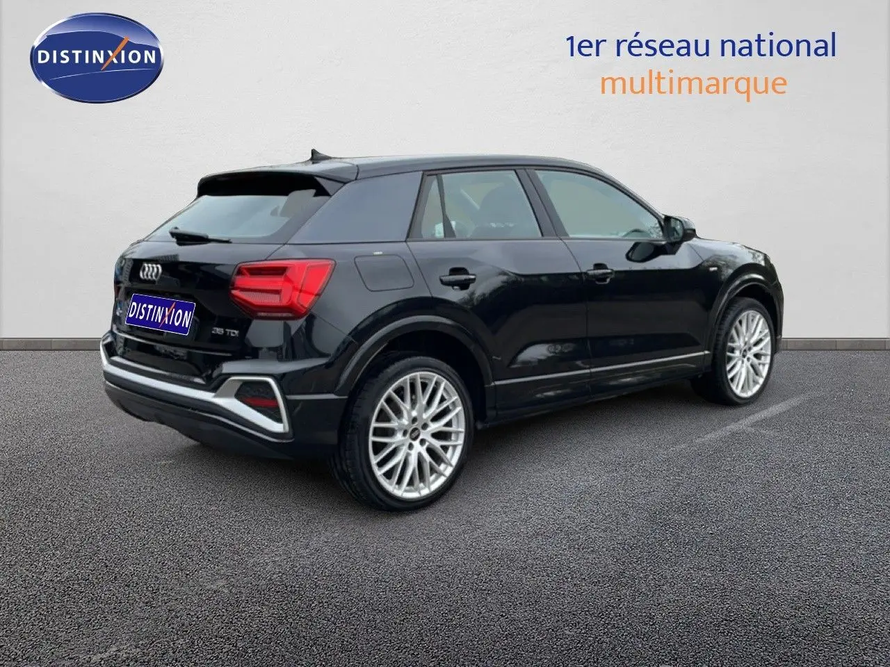 Audi Q2 noir mito metal en 3/4 arrière droit, avec jantes alliage et détails S-Line visibles sur carrosserie.