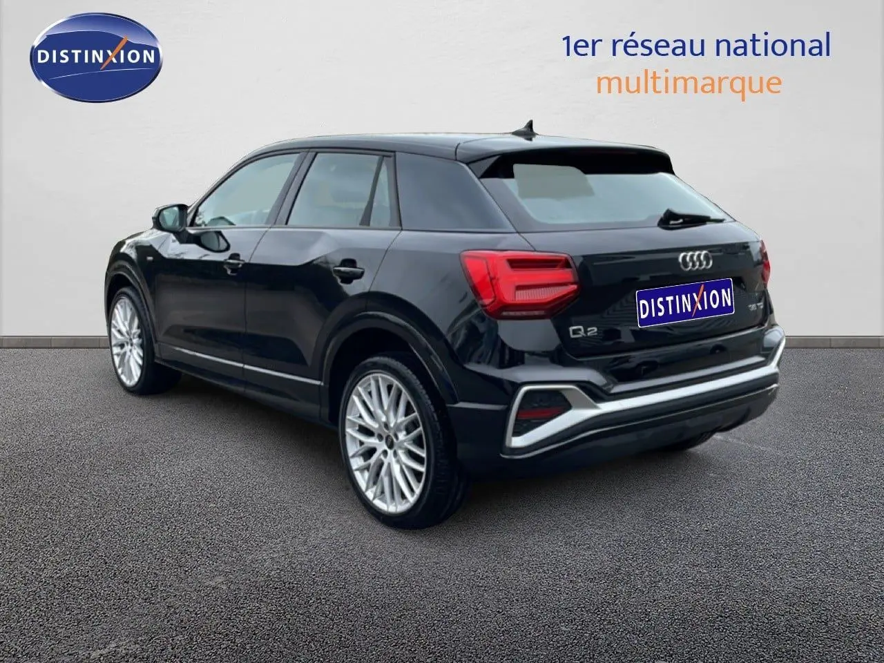 Audi Q2 noir mito metal en 3/4 arrière droit, mettant en valeur ses jantes alliage et ses feux arrière LED distinctifs.