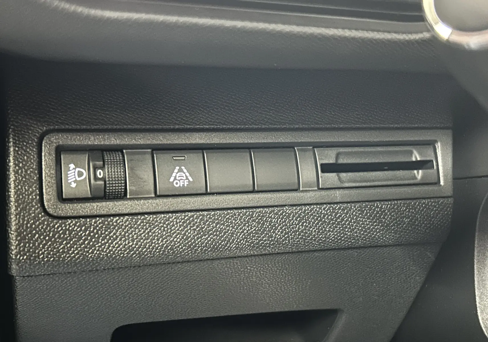 Détail intérieur du tableau de bord côté gauche du Peugeot 5008 bleu, montrant les commandes d'éclairage et d'assistance.