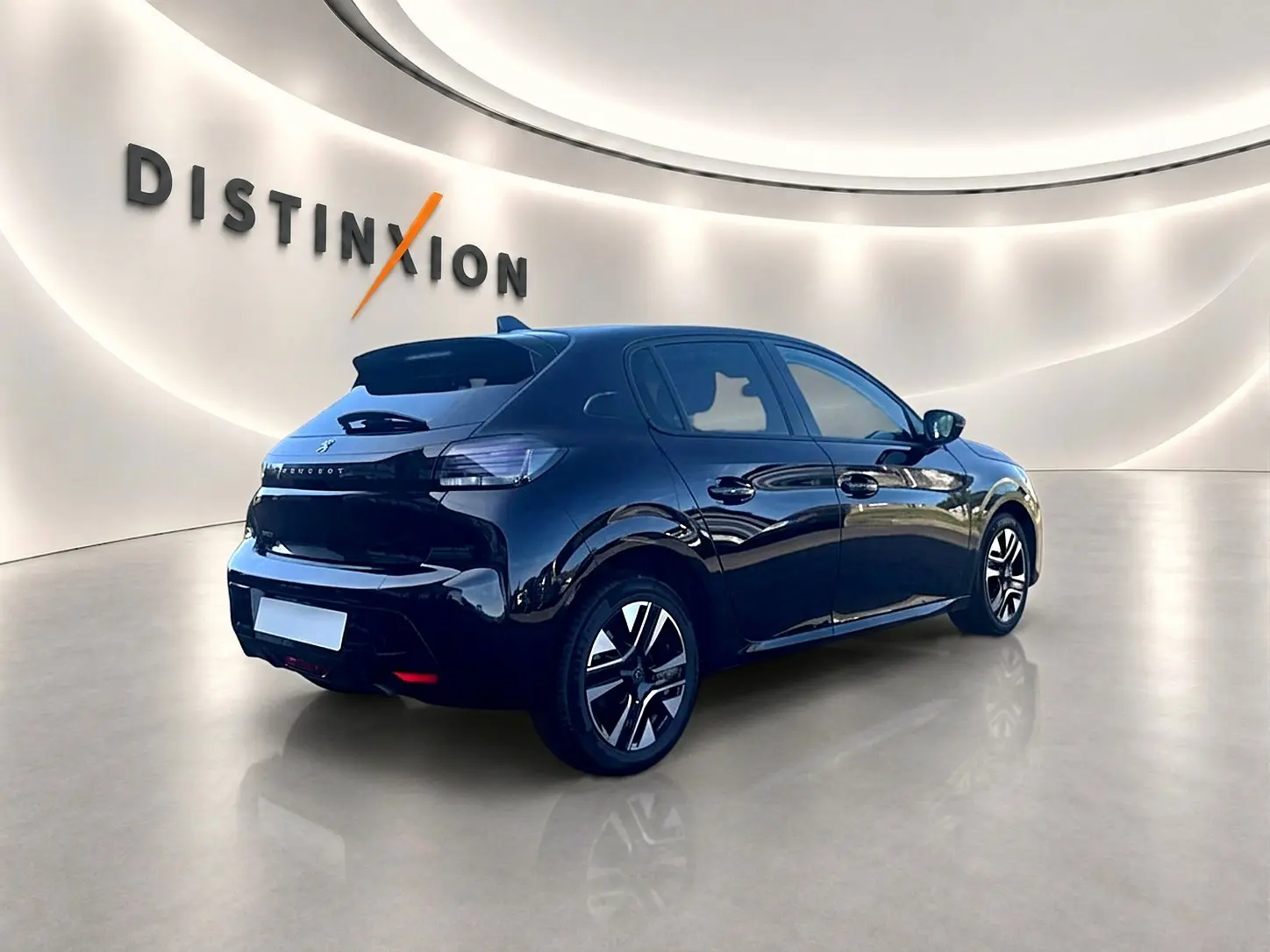 Peugeot 208 noire vue 3/4 arrière droit dans un showroom lumineux avec jantes alu et vitres teintées.