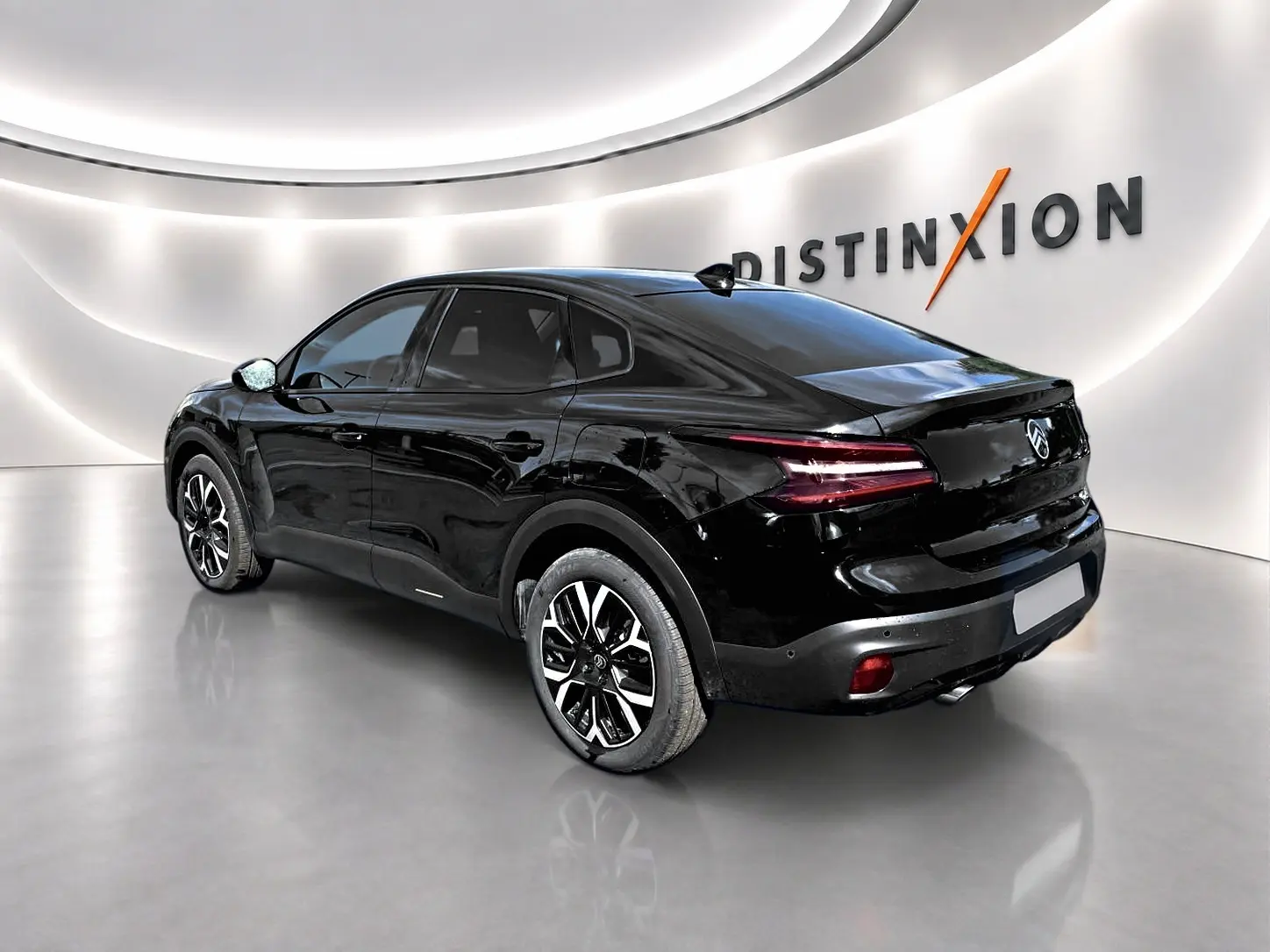 Vue 3/4 arrière droite d'une Citroën C4 X noire 2025 avec jantes alu et feux arrière LED distinctifs.