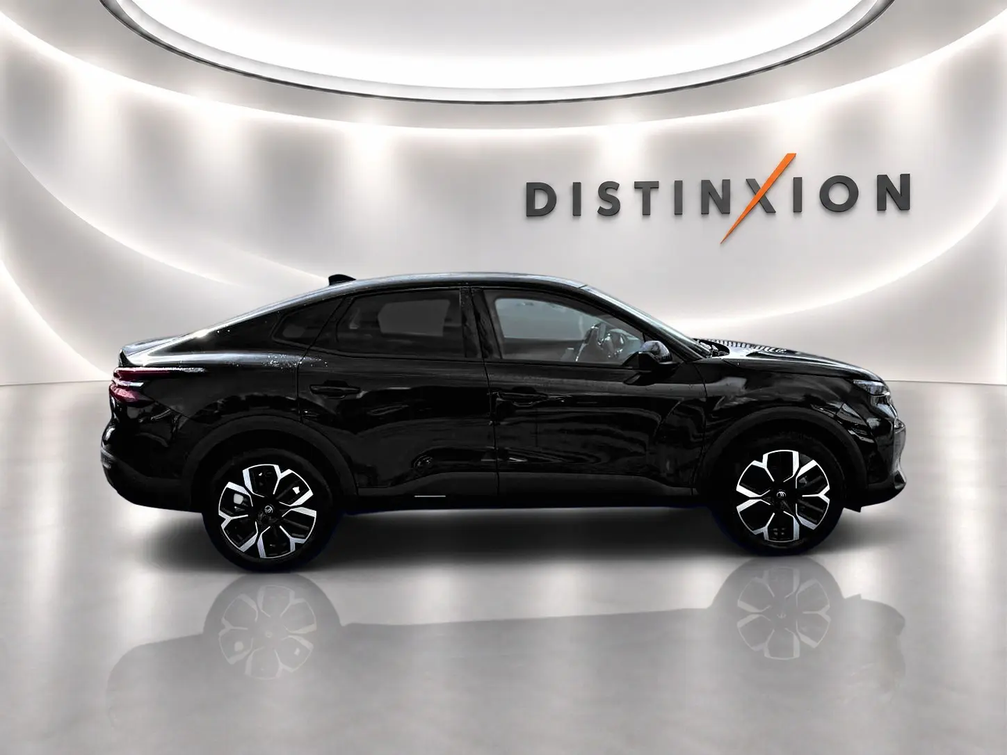 Profil côté gauche de la Citroën C4 X noire 2025 avec jantes alu distinctives dans un studio lumineux.