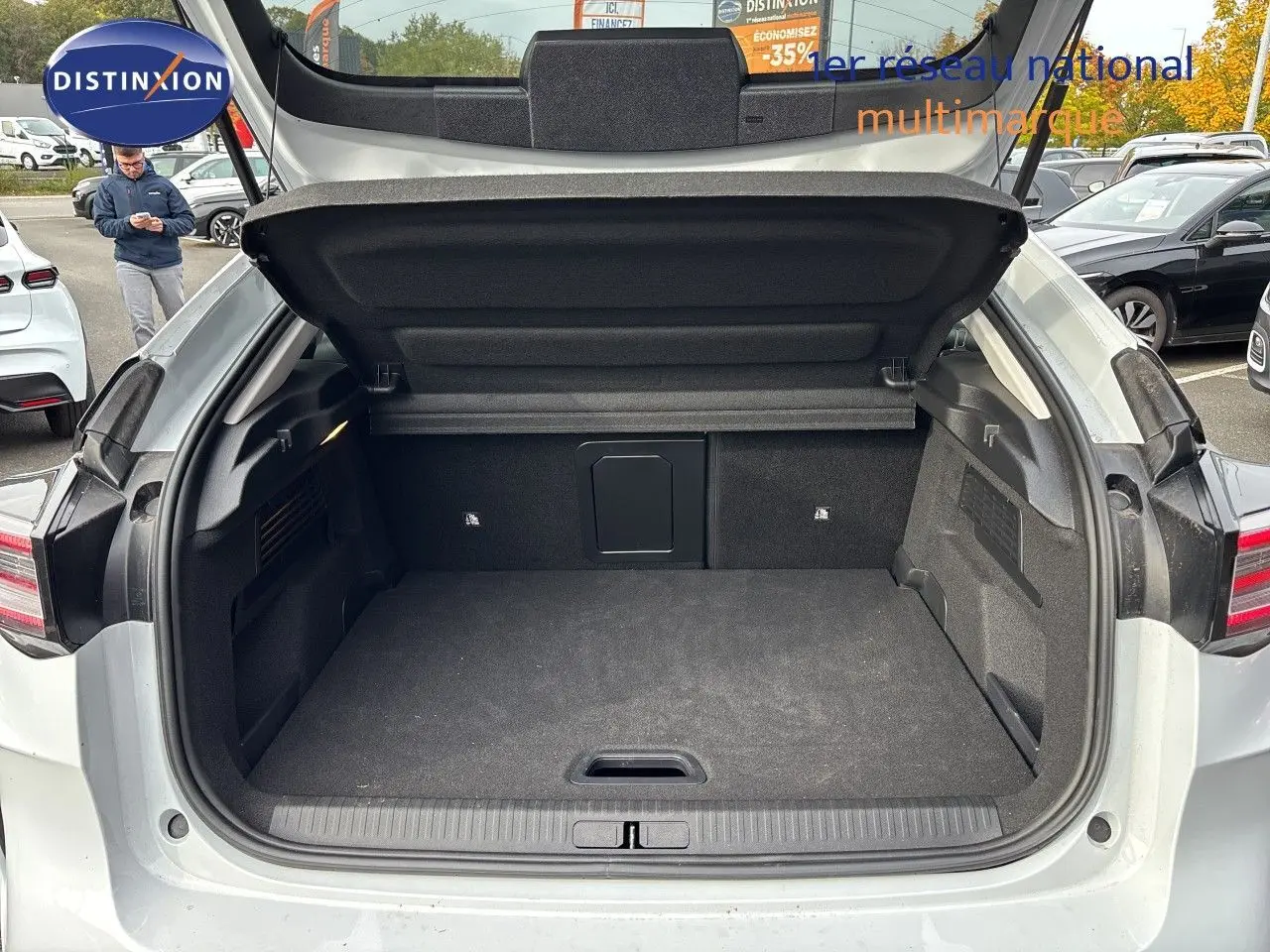 Coffre ouvert vu de l'arrière d'une Citroën C4 Hybrid blanche, montrant un espace de chargement propre et spacieux.