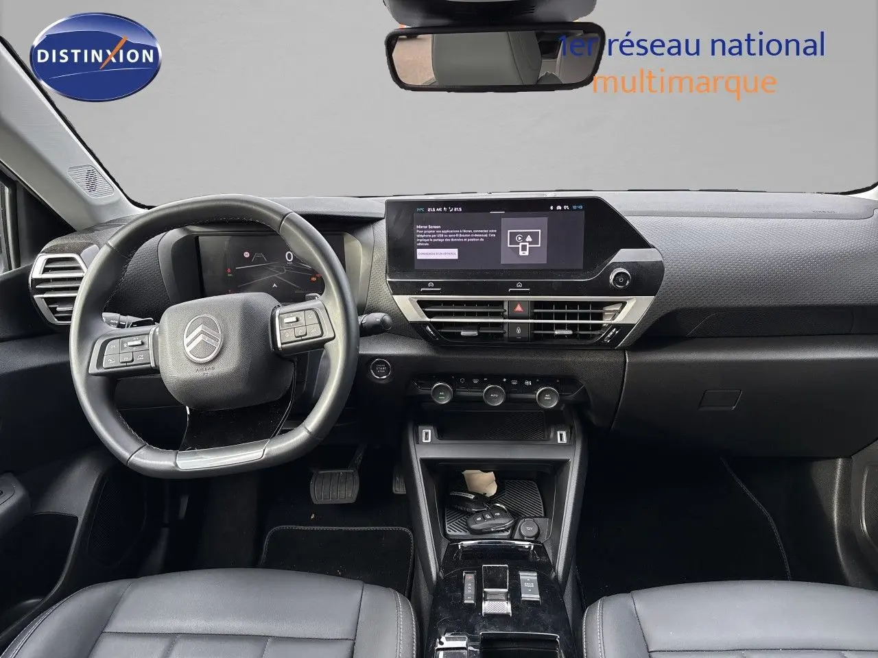 Vue intérieure frontale du tableau de bord et volant noir de la Citroën C4 Hybrid 2025 avec écran tactile central.