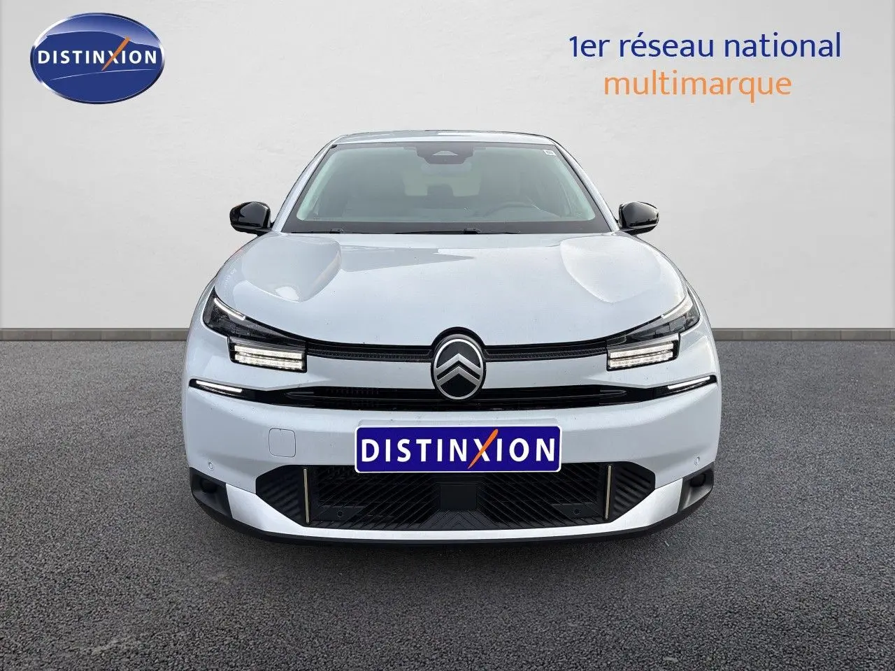 Vue frontale d'une Citroën C4 Hybrid 145ch blanche Okenite Metal avec calandre noire et feux LED distinctifs.