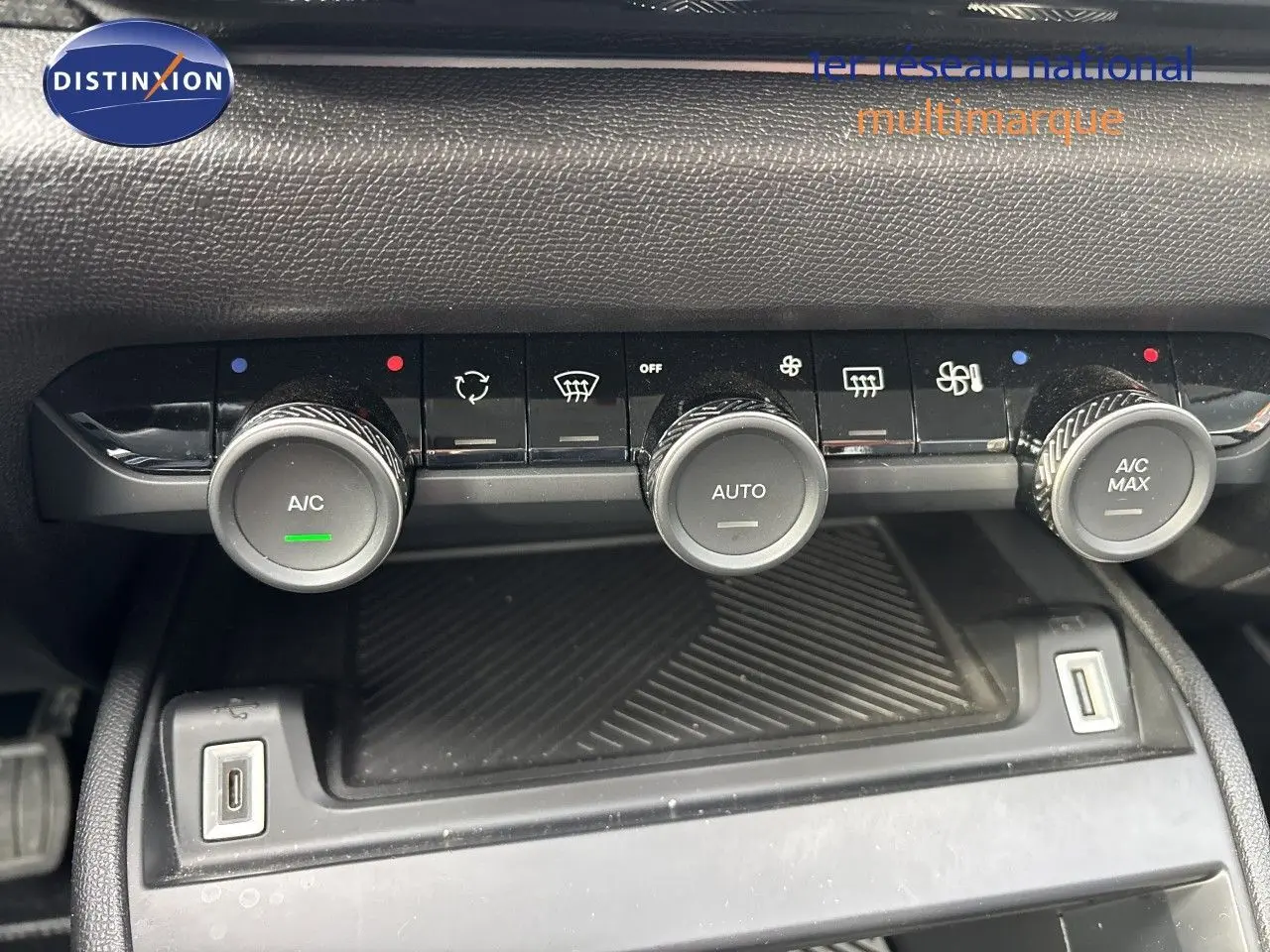 Gros plan sur la console centrale de la Citroën C4 Hybrid 2025, montrant les commandes de climatisation et deux ports USB.